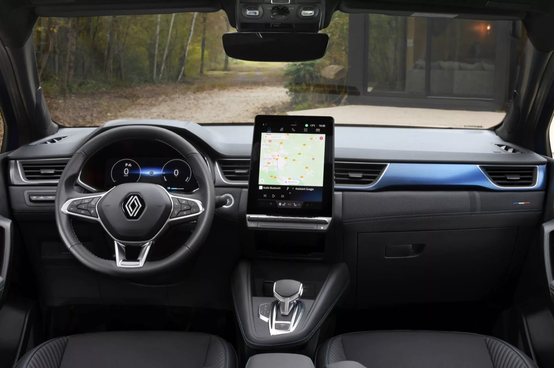 Interiérový pohled z zadního sedadla Renault Captur 2024, zdůrazňující digitální přístrojový panel, multifunkční volant, velký dotykový informačně-zábavní systém a minimalistický design středové konzoly