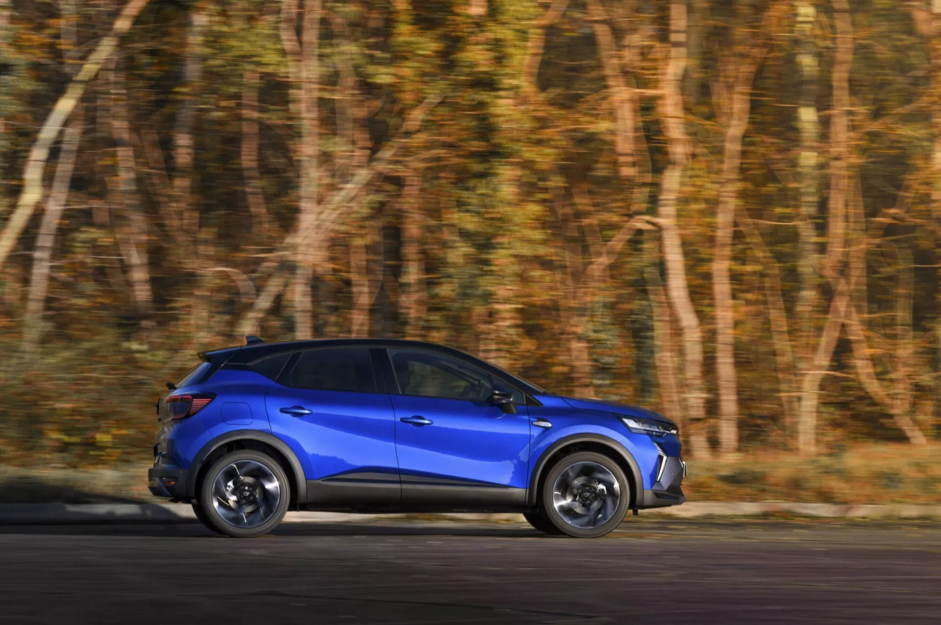 Modré SUV Renault Captur II Facelift 2024 v pohybu, ukazující dynamické designové prvky a technologii LED z bočního profilu s viditelným rozmazáním pohybu