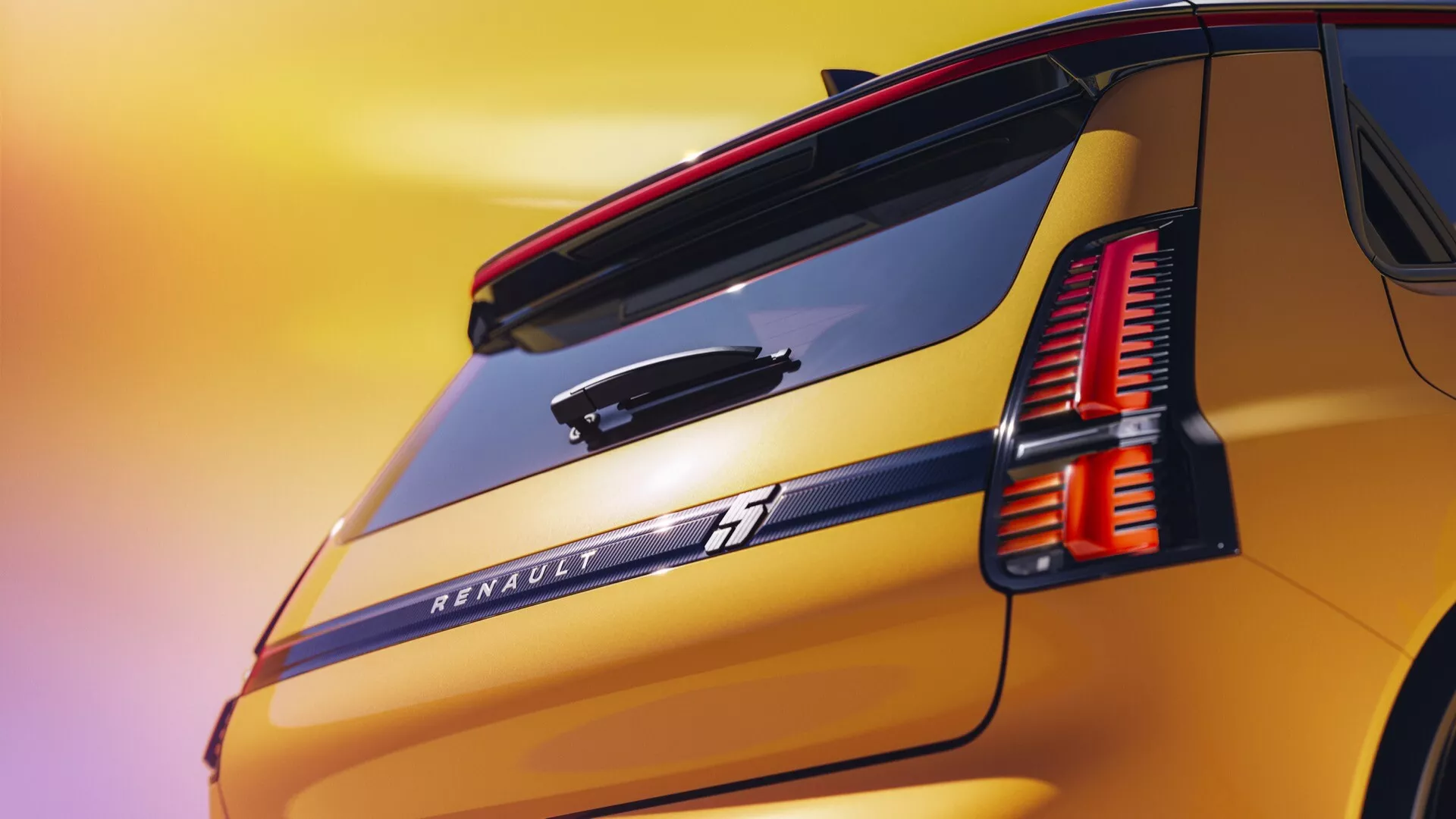 Detailní pohled na zadní část Renaultu R5 2024 s LED zadními světly, označením Renault, zadním spoilerem, strmým zadním oknem, metalickým zlatavě žlutým lakem a zadním stěračem v atmosféře západu slunce