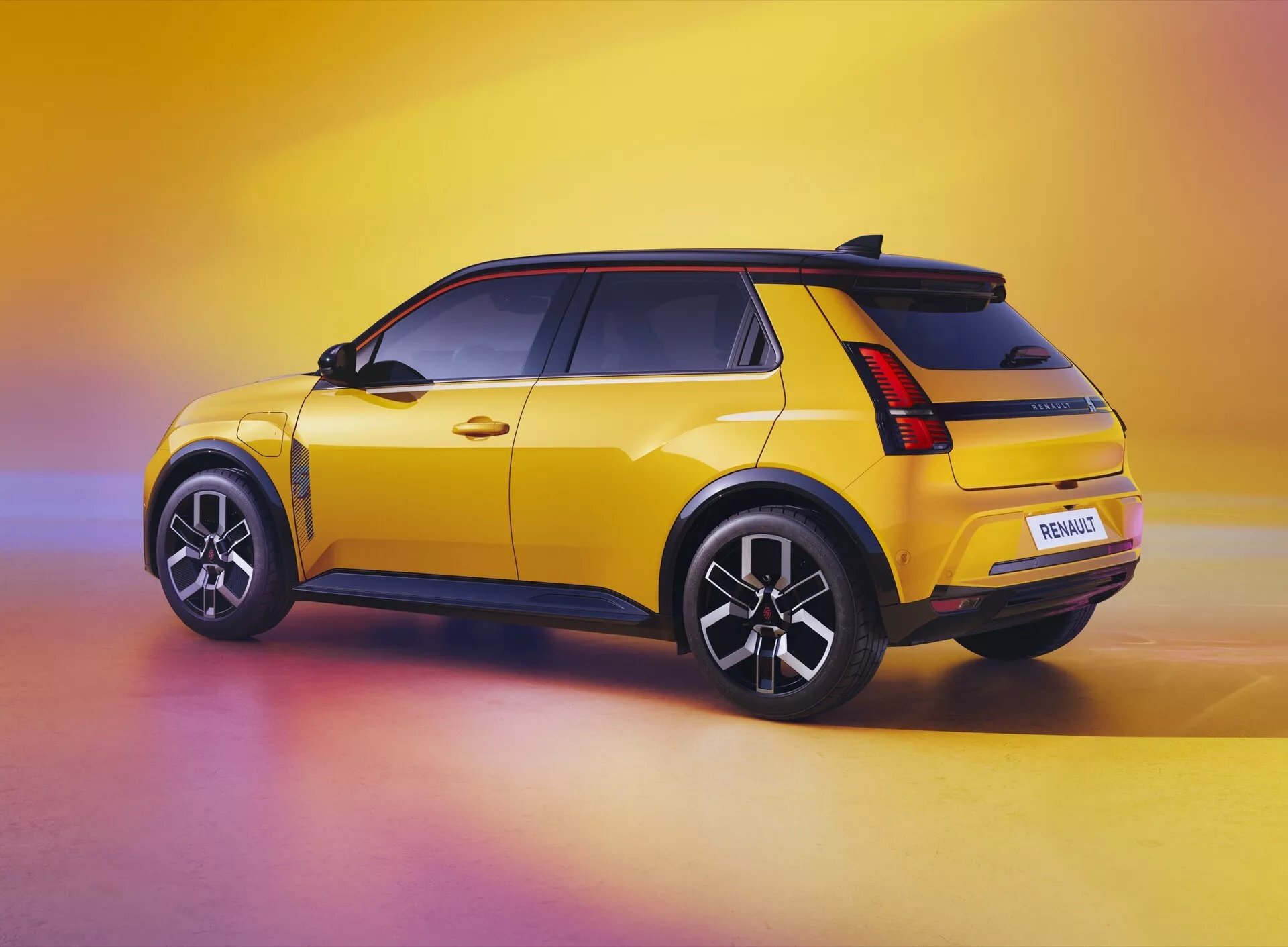 Žlutý Renault R5 2024 ukazující svůj boční profil a zadní design z trojčtvrtečního úhlu, zdůrazňující spoiler na střeše, LED zadní svítilny, svalnaté oblouky kol, vícepaprsková kola a technologicky vylepšený zadní nárazník