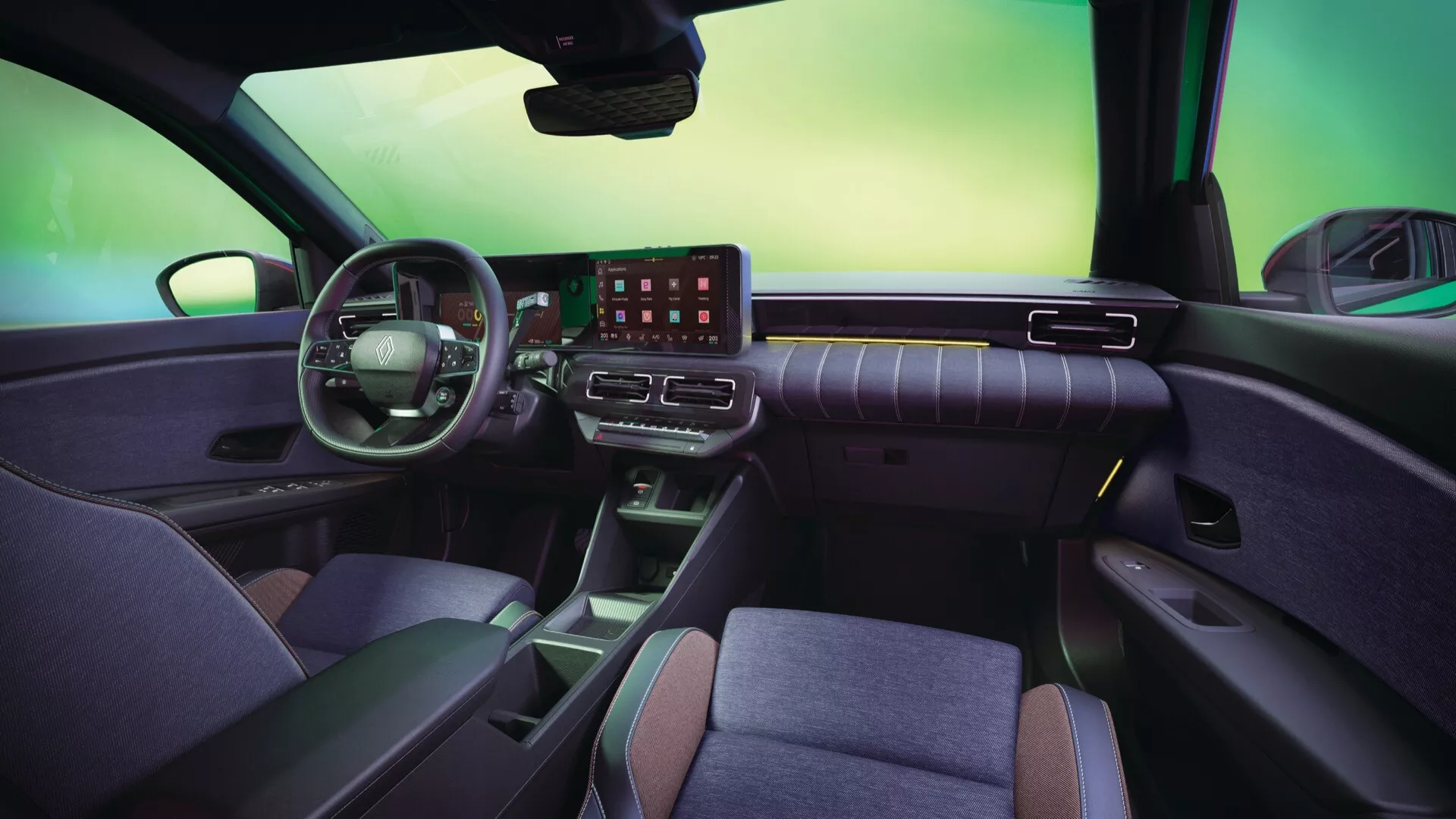 Interiér Renaultu R5 2024 z pohledu ze zadního sedadla s širokoúhlým objektivem zobrazující palubní desku, dotykový displej, digitální přístrojovou desku, volant s ovládacími prvky a ergonomická přední sedadla