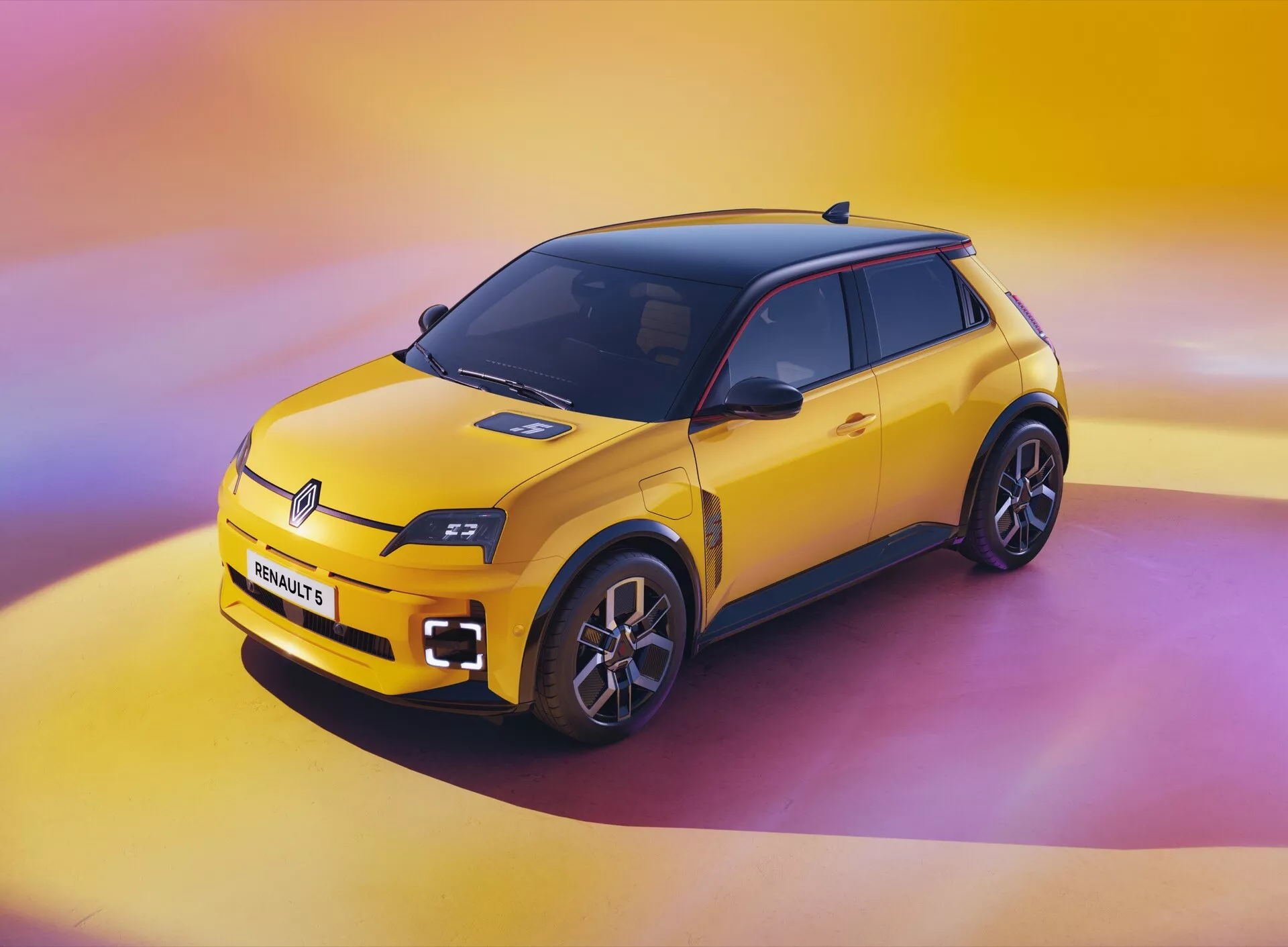Renault R5 2024 ve výrazné žluté s černou střechou, předvádějící moderní designové prvky a funkce elektrického vozidla v ateliéru s přechodem od žluté k růžovo-fialovému pozadí