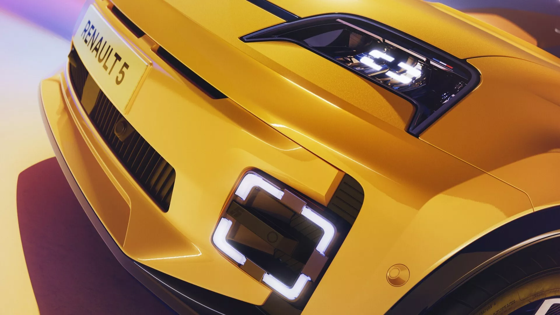Detailní pohled na přední levý roh Renaultu R5 2024 s detailně zobrazeným LED světlometem, sportovně řešenou kapotou a částí masky s osvětleným emblémem v jasně žluté barvě