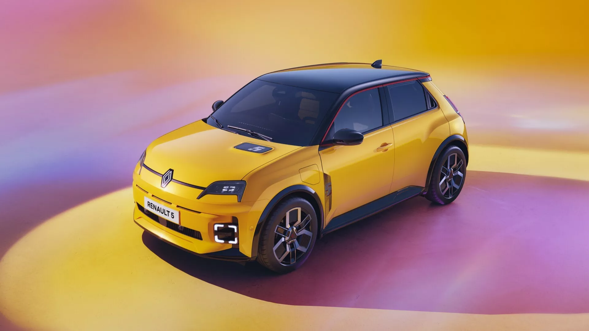 Snímek z vysokého úhlu modelu Renault R5 2024 představující jeho žlutý kompaktní sportovní design hatchbacku s LED světlomety, velkou mřížkou, aerodynamickými liniemi, slitinovými koly s více paprsky a dvoubarevným barevným schématem na pozadí živých růžových a žlutých přechodů