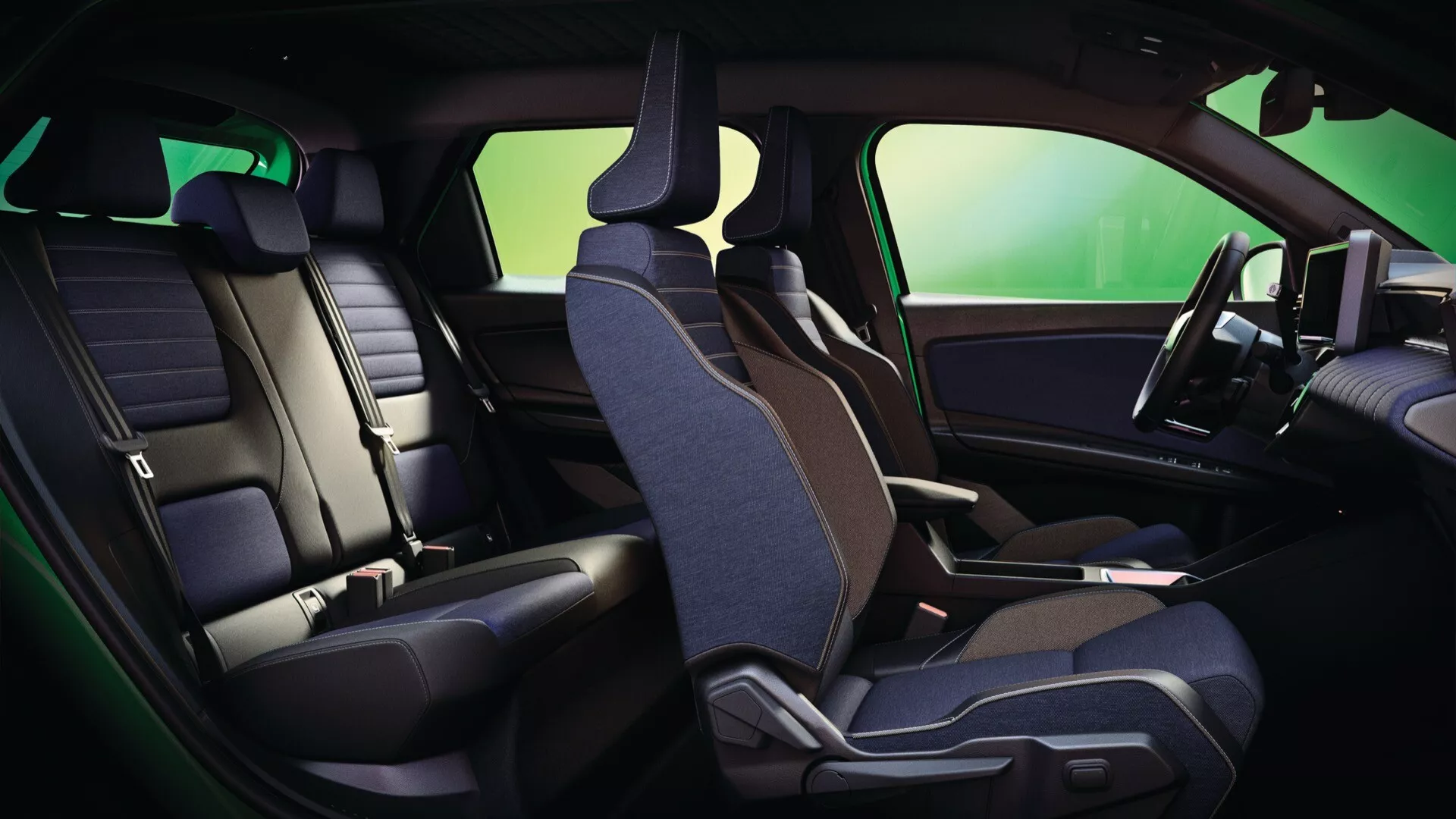 Interiér Renault R5 2024 s důrazem na ergonomické dvoubarevné kožené a textilní uspořádání sedadel z boční perspektivy, prezentující přední sedadlo spolujezdce a zadní sedadla s integrovanými prvky dveřního panelu