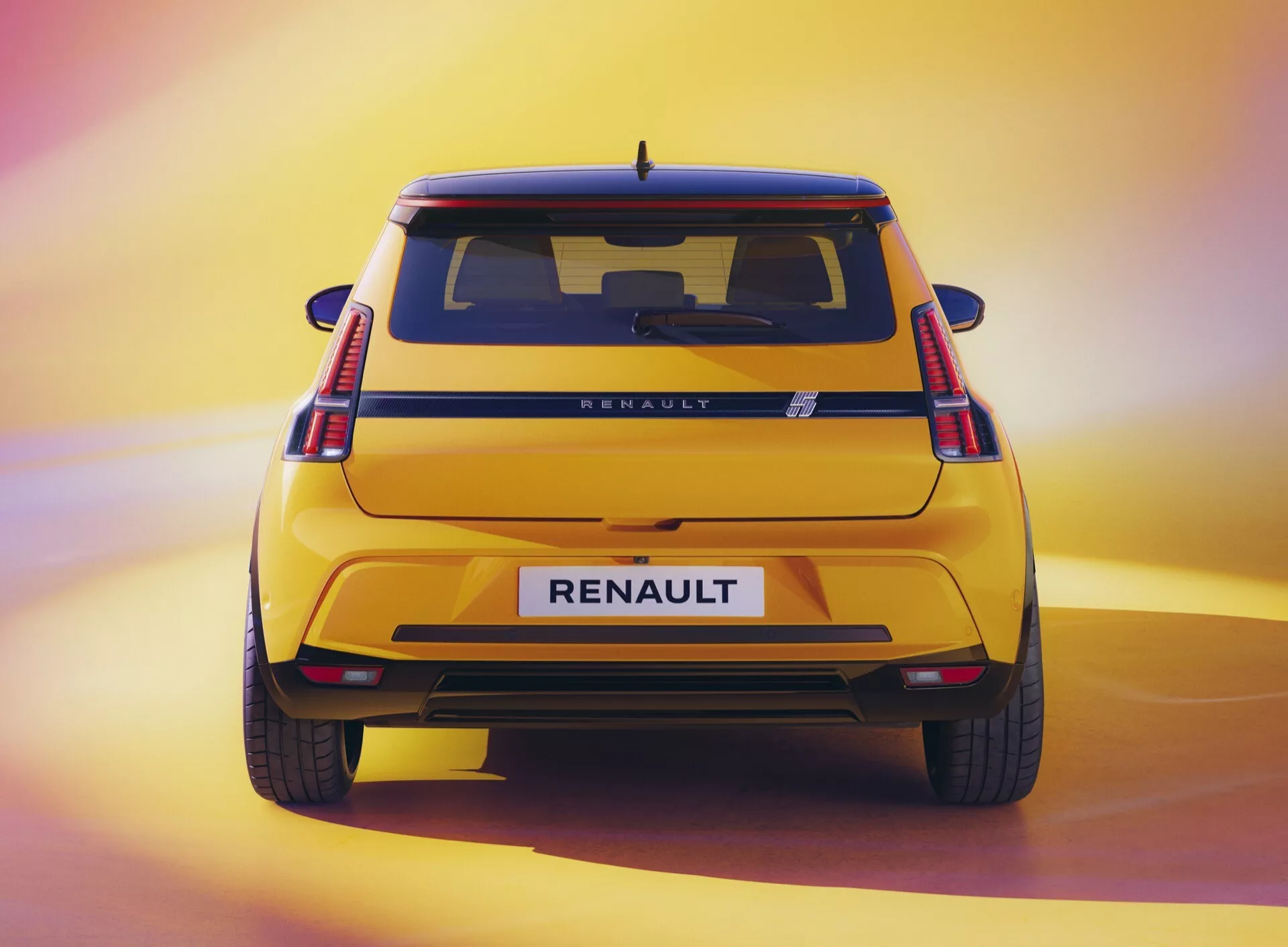 Zadní pohled na Renault R5 2024 předvádějící výšku, zadní design s C-tvarovanými LED zadními světly, označení RENAULT a metalický lak ve světle osvětleném studiu