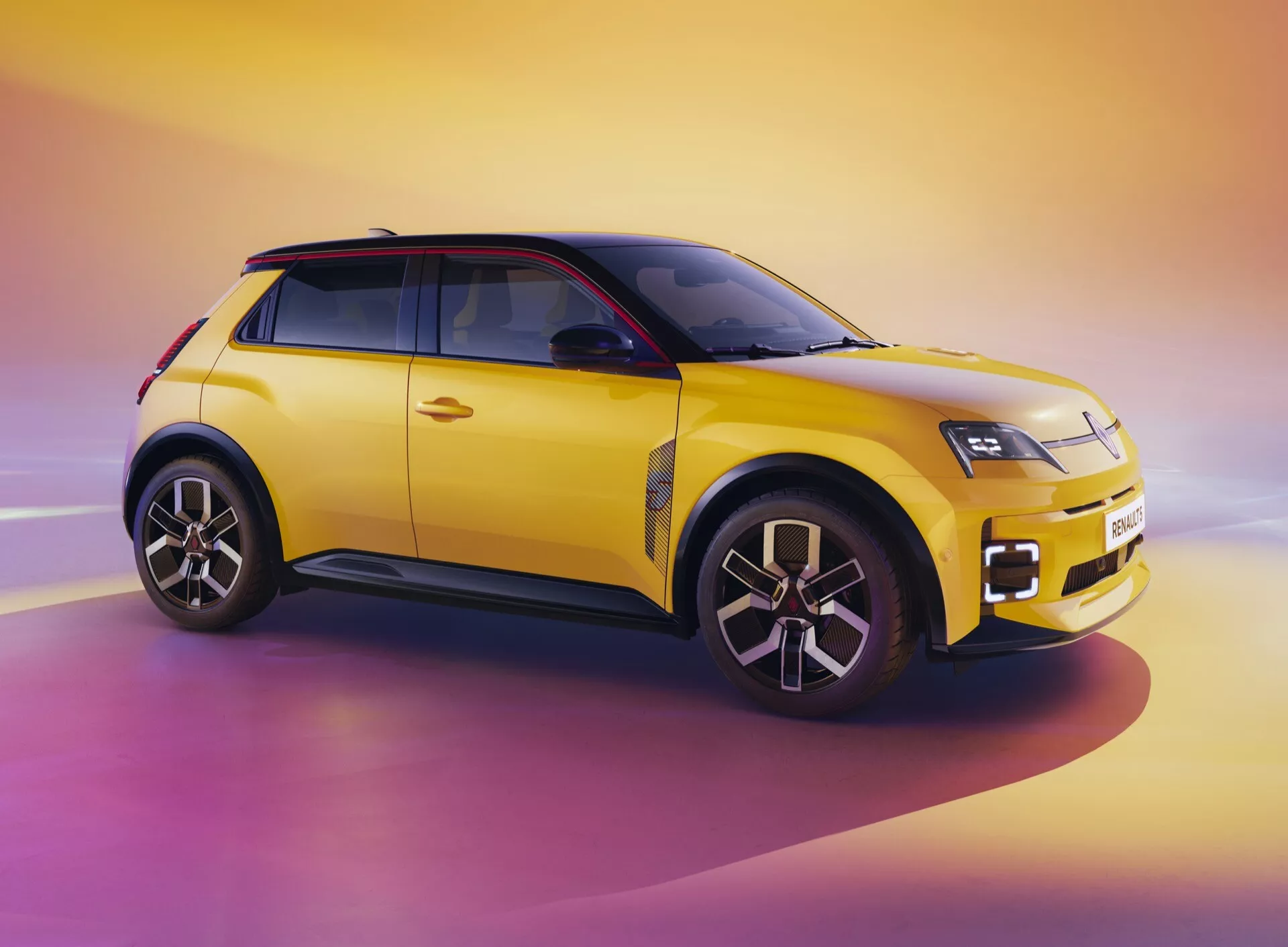 Renault R5 III 2024 ve výrazné žluté s černou střechou zobrazuje svůj moderní design kompaktního SUV z úhlu tři čtvrtě zepředu, zdůrazňuje LED světlomety, kola z lehké slitiny s více paprsky a dvoubarevný barevný schéma na dynamickém pozadí východu slunce