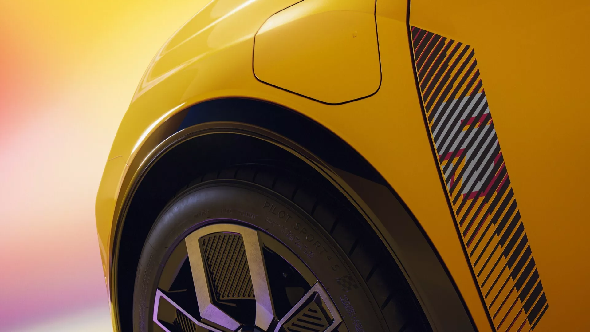 Detailní zadní pohled na Renault R5 2024 ve výrazné žluté barvě, zvýrazňující úhlový zadní ventil a moderní dvoutónový design kola, zdůrazňující výkonově orientovanou karoserii a nízkoprofilovou pneumatiku.