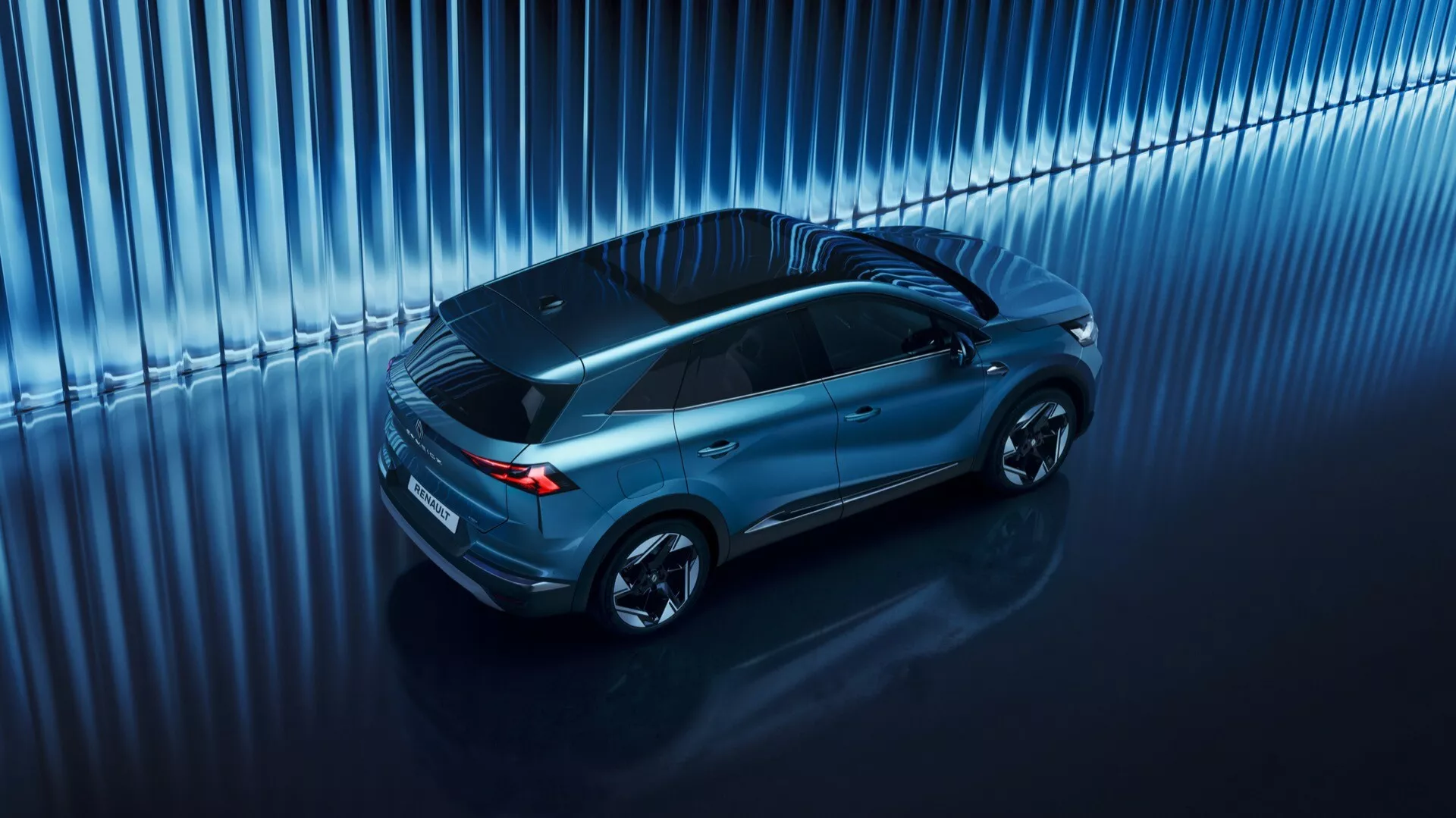 Pohled shora na SUV Renault Symbioz 2024, zobrazující elegantní, aerodynamický design s panoramatickou střechou a vícepaprskovými litými koly, odrážející vysoce kvalitní materiály a moderní technologie ve studiovém prostředí.