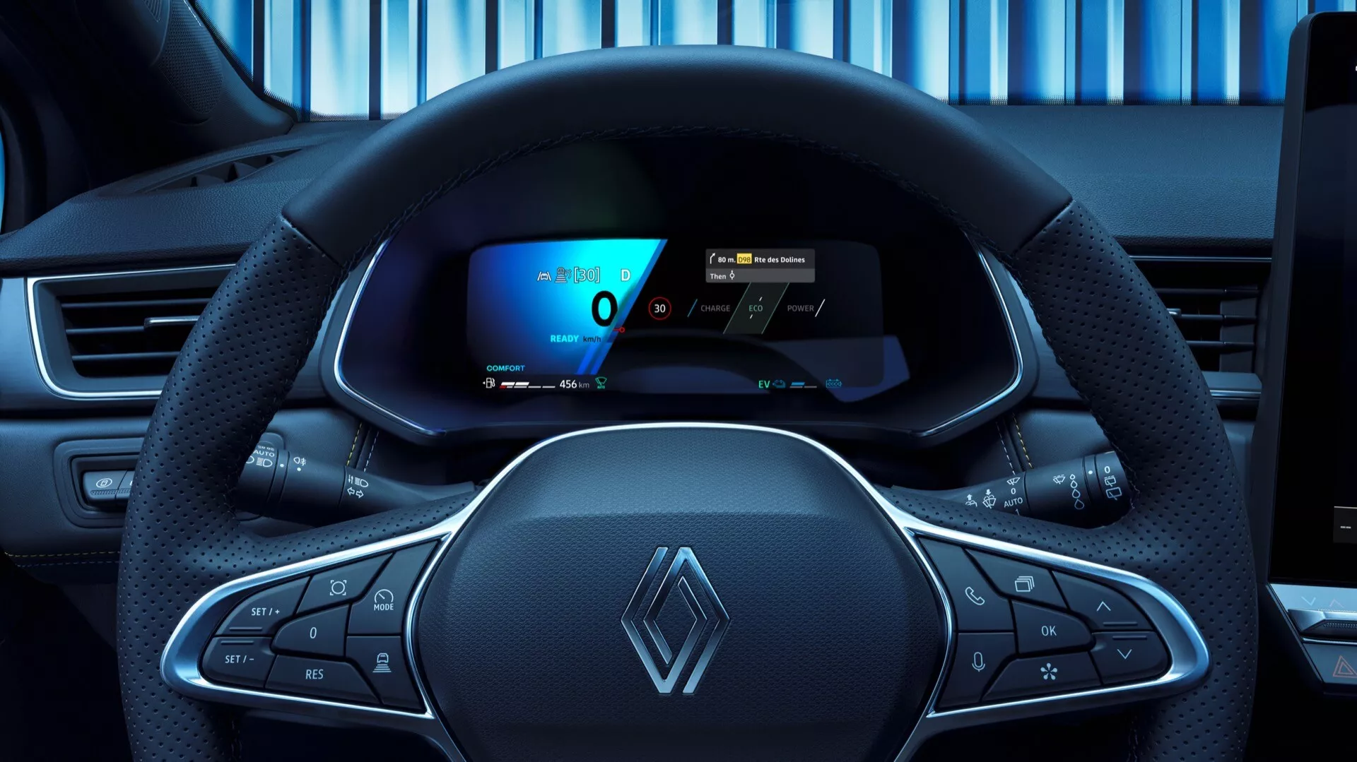 Pohled z pozice řidiče na Renault Symbioz 2024 1. generace, představující moderní, mírně sportovní design volantu s vícefunkčními tlačítky a výrazným logem Renault. Digitální přístrojový panel za volantem zobrazuje rychloměr, ukazatel výkonu a navigační mapu, což podtrhuje pokročilou technologii vozidla. Palubní deska naznačuje možnou centrální dotykovou obrazovku infotainment systému.
