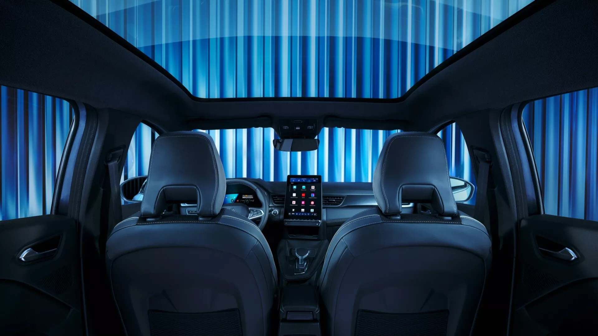Pohled ze zadního sedadla na interiér Renault Symbioz 2024 první generace, který ukazuje komplexní design kabiny a pokročilé technologie. Obrázek zdůrazňuje dvě přední kožená sedadla s kontrastním prošitím, velký centrální dotykový displej pro infotainment, minimalistickou palubní desku s horizontálními liniemi, multifunkční volant, digitální přístrojový panel a ambientní osvětlení.