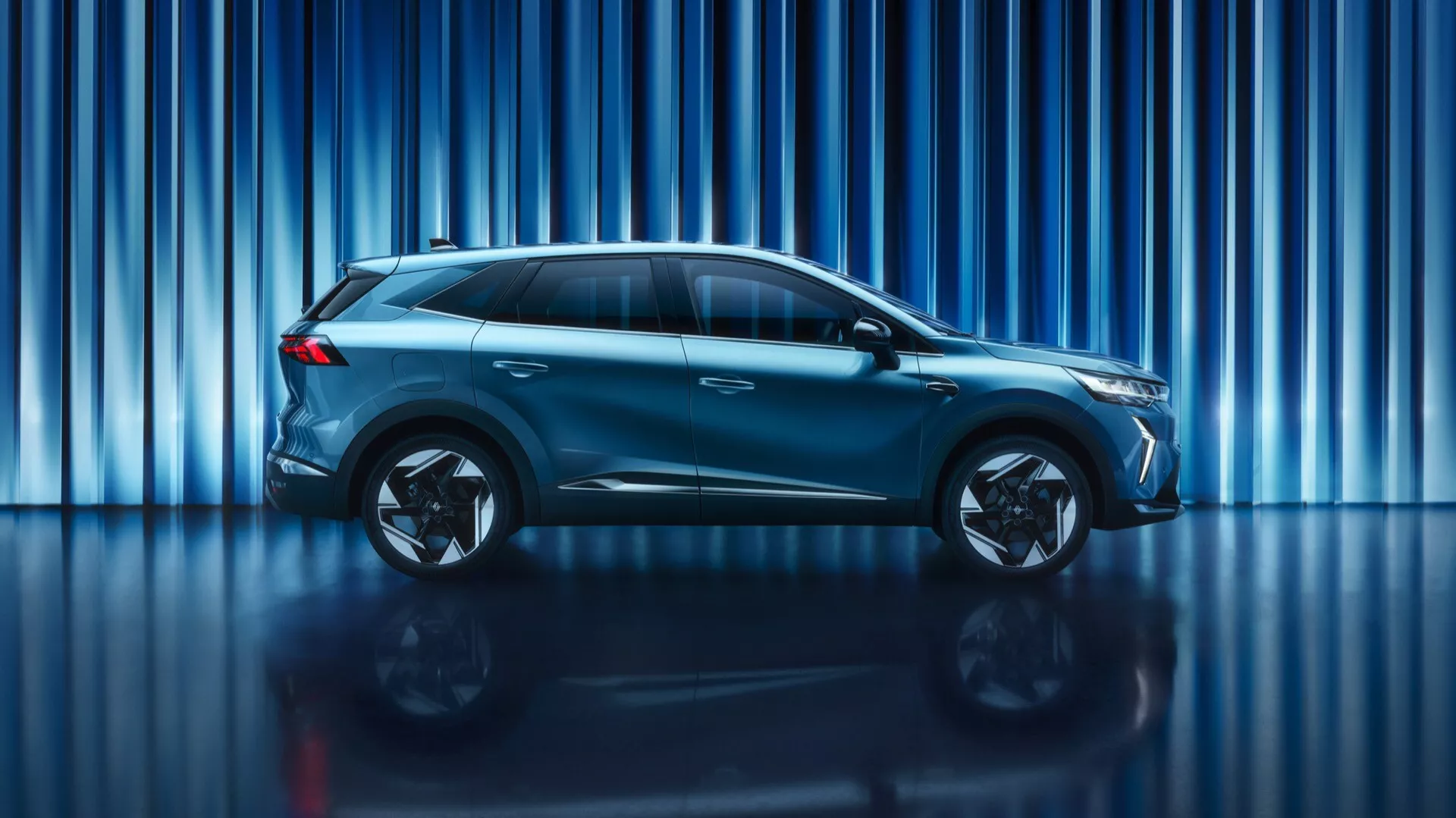 Boční profil Renaultu Symbioz z roku 2024, který ukazuje svůj elegantní aerodynamický design, vícepaprsková hliníková kola, zvýšenou světlou výšku a integrovaná boční zrcátka, což zdůrazňuje moderní SUV/crossover ve studiovém prostředí.