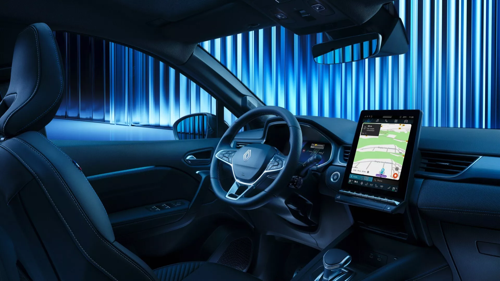Vnitřní záběr na Renault Symbioz 2024 zaměřený na moderní palubní desku s velkým svisle orientovaným dotykovým displejem, víceúčelovým volantem, digitálním přístrojovým panelem a elegantním designem s koženkovými sedadly a modrým ambientním osvětlením.