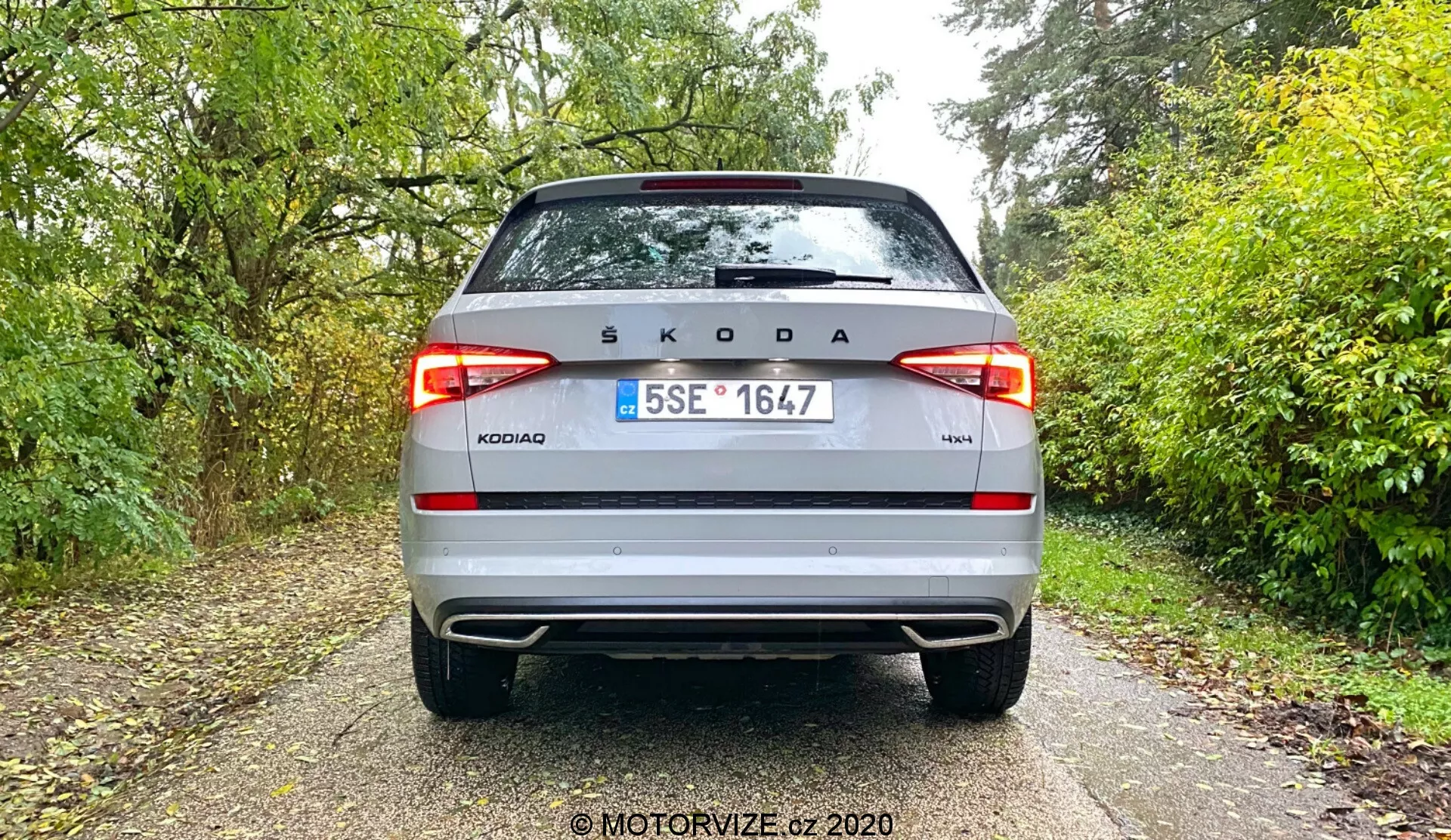 Pohled na zadní úhel stříbrné Škody Kodiaq 2017. Výrazně zobrazuje zadní logo Škoda uprostřed, název modelu 'KODIAQ' a označení výbavy '4x4', s českou poznávací značkou mezi moderními LED zadními světly, dvoubarevným nárazníkem, odrazkami a případně parkovacími senzory.