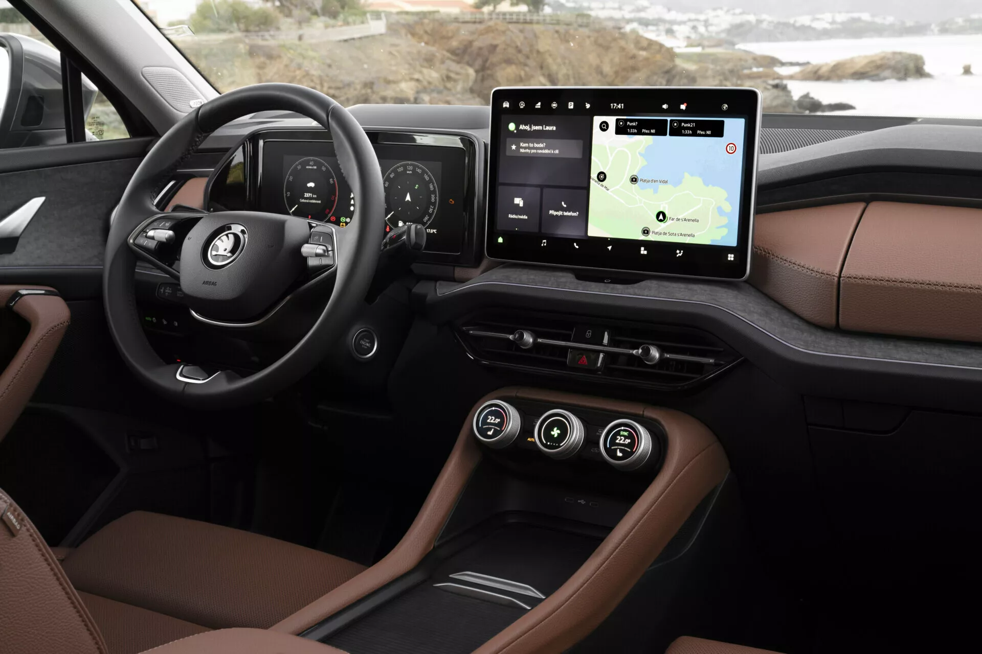 Detailní pohled na interiér Škoda Kodiaq 2024 z pohledu řidiče, zobrazující palubní desku a technologické prvky včetně digitálního přístrojového panelu, dotykového infotainment systému s navigací, luxusního dvoubarevného čalounění, ambientního osvětlení a moderních možností připojení