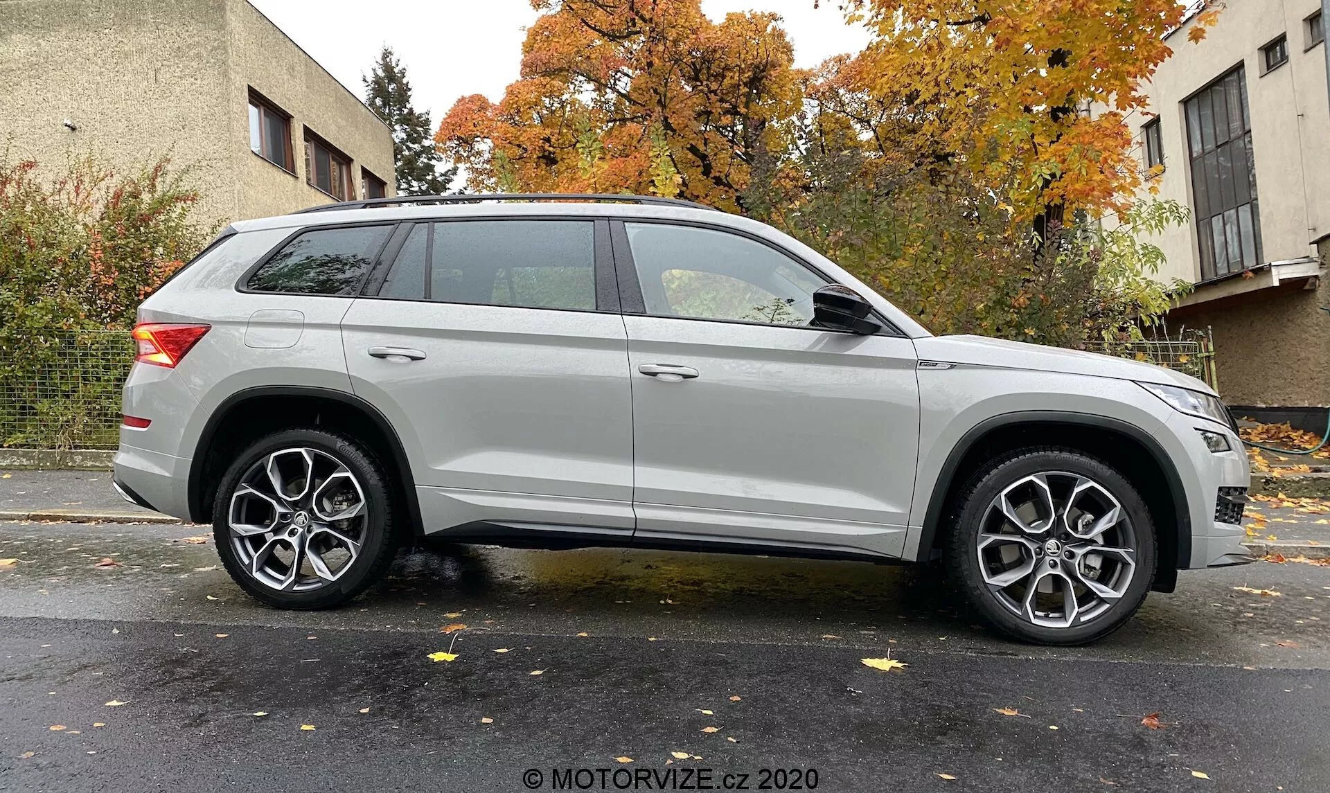 Boční profil stříbrného SUV Skoda Kodiaq 2017, snímek pořízený z mírného úhlu, zdůrazňuje přední kolo a blatník. Ukazuje délku vozidla a designové prvky jako moderní světlomety, vícepaprskové litinové disky, výraznou charakteristickou linii, střešní ližiny a elegantní zadní světla. Neutrální pozadí s rovnoměrným osvětlením. Fotografický kredit: MOTORVIZE.cz 2020.