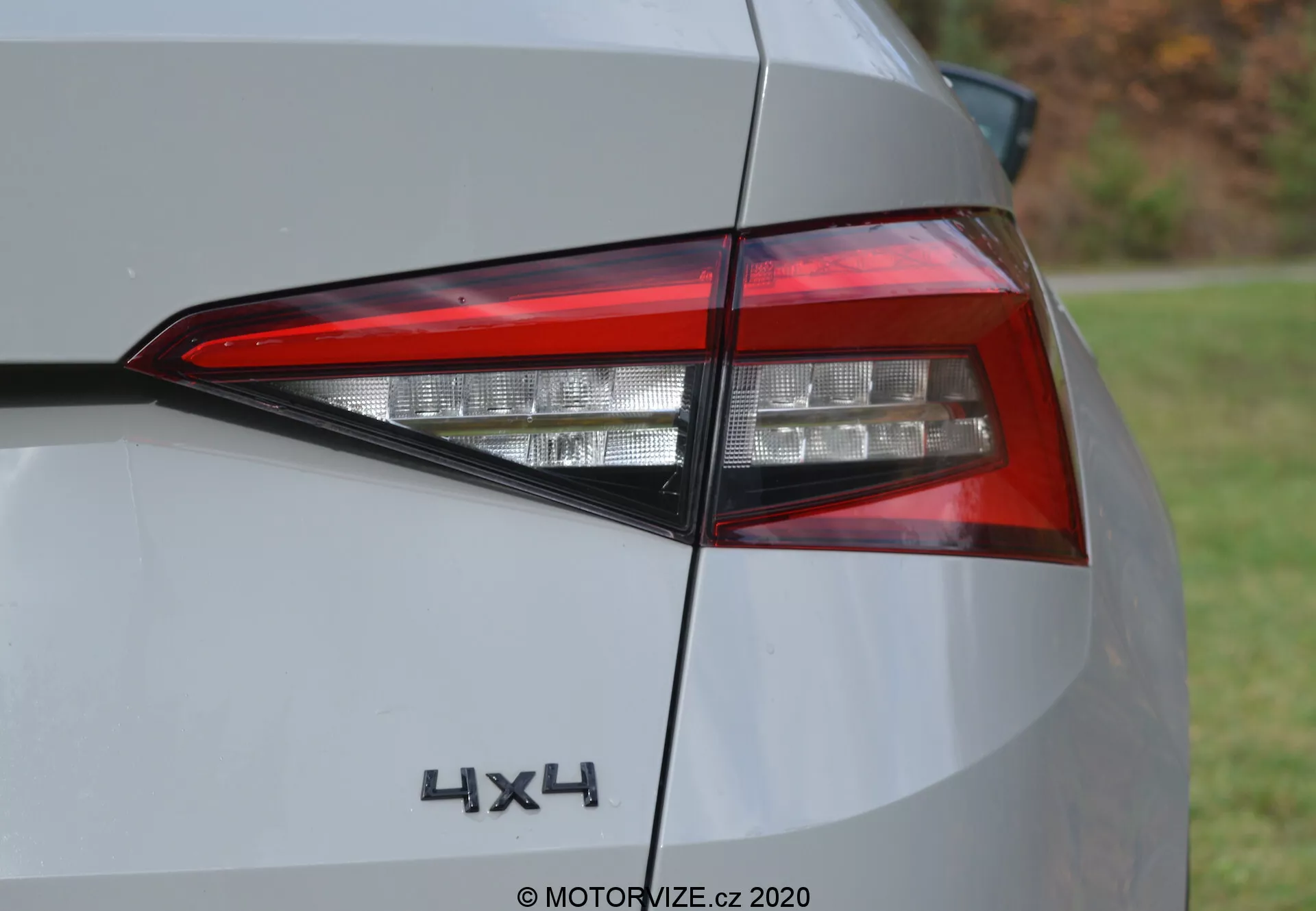 Detailní pohled na zadní levé světlo modelu Škoda Kodiaq 2017 s hranatým LED designem, lesklým světle zbarveným lakem a 4X4 označením, zdůrazňující detaily moderního vozidla a funkci pohonu všech kol.