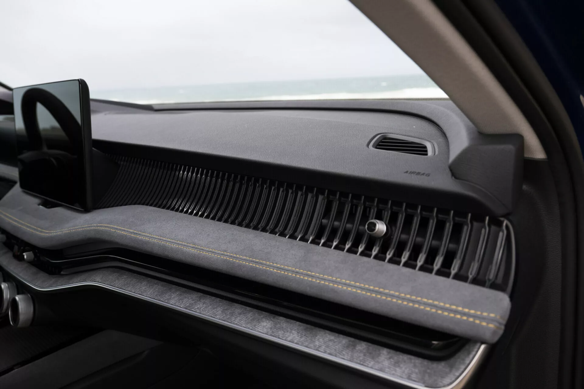 Detailní pohled do interiéru Škoda Superb Combi 2024, zaměřený na palubní desku pro spolujezdce s minimalistickým designem, prémiovým větráním a odkládacím prostorem