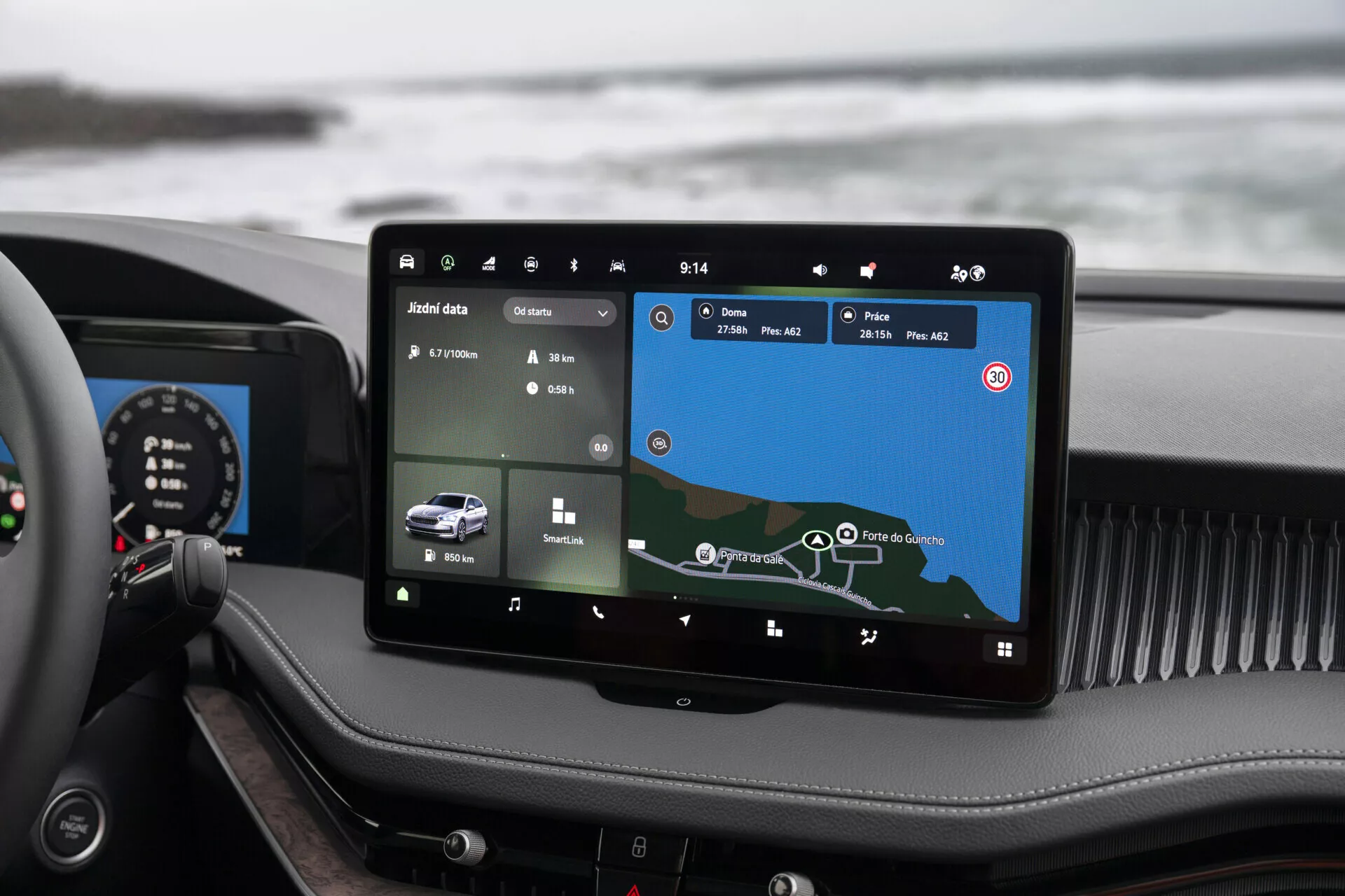 Interiér Škoda Superb Combi 2024 s vertikálně umístěným velkým dotykovým infotainment systémem ve stylu tabletu s GPS navigací a funkcemi připojení na palubní desce, pohled z perspektivy předního spolujezdce