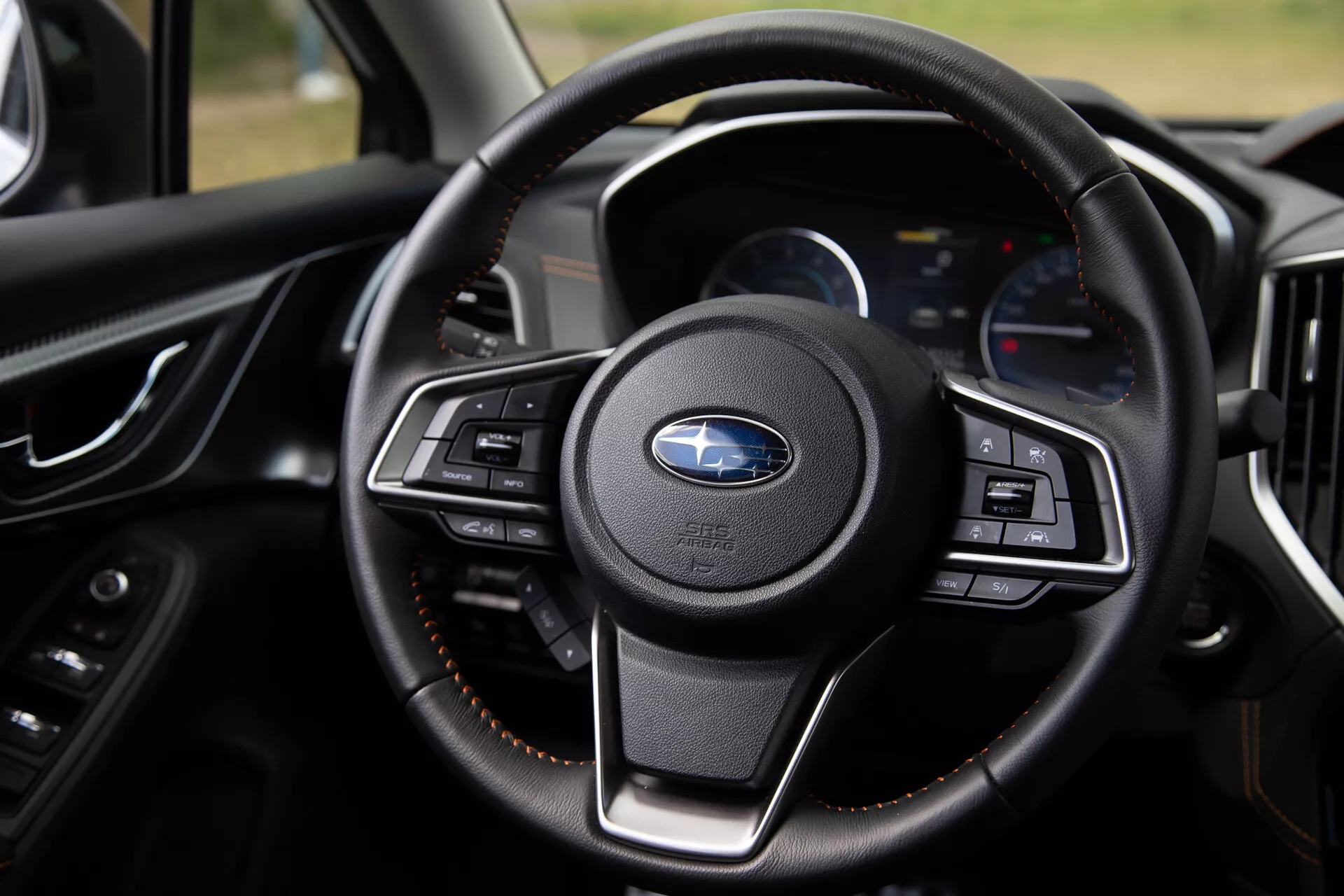 Detailní pohled na volant Subaru XV 2021 s multifunkčními tlačítky, luxusním koženým obšitím a moderním palubním panelem s digitálními displeji