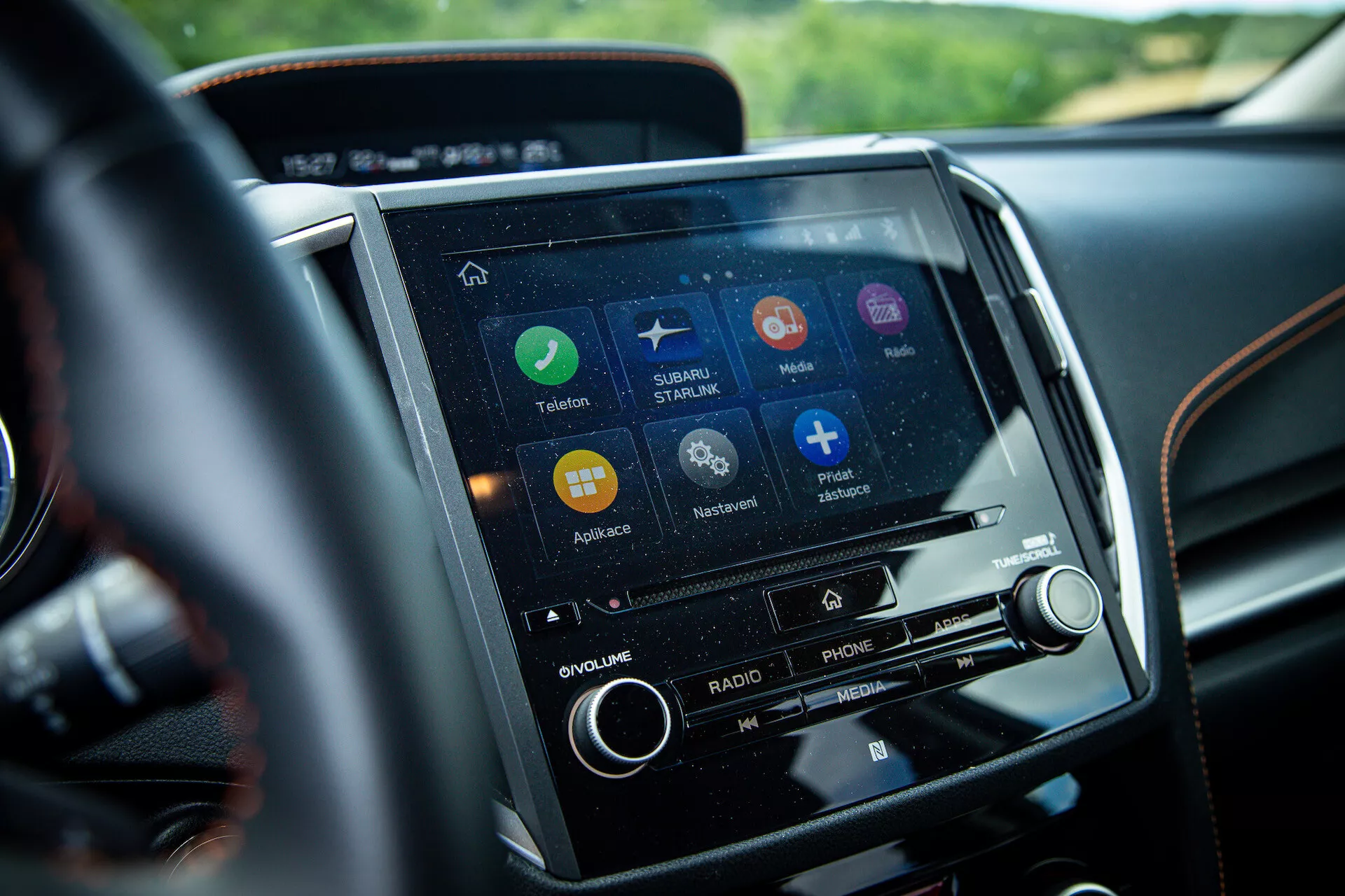 Detailní pohled na dotykový infotainment systém Subaru XV 2021 umístěný na středové konzole, z pohledu řidiče, s aplikacemi pro navigaci, připojení telefonu a streamování hudby