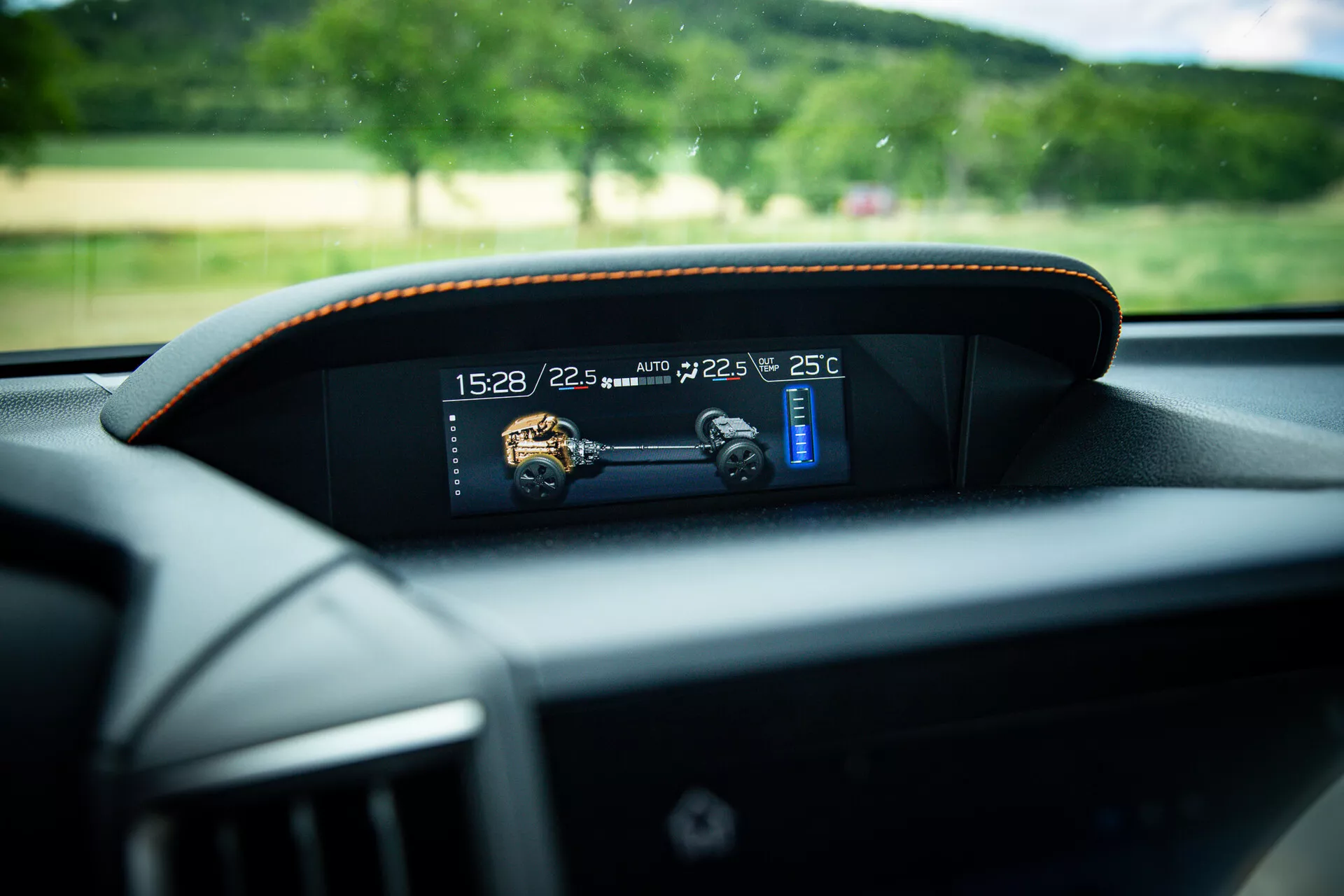 Detailní pohled na moderní digitální palubní desku v Subaru XV 2021, zobrazující ukazatele času, teploty a rychlosti s jemným kontrastním prošíváním kolem rámečku, pořízený z perspektivy řidičova sedadla