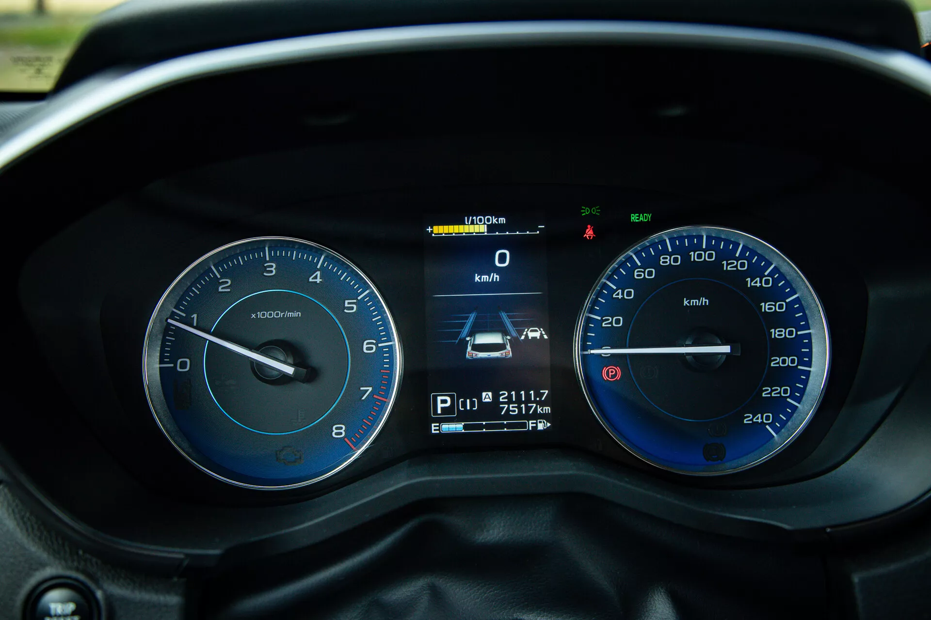 Detailní pohled z perspektivy řidiče na přístrojový panel Subaru XV 2021 s tachometrem, rychloměrem a digitálním displejem zobrazujícím rychlost, polohu převodovky, stav kilometrů, údaje o cestě a různé kontrolky a varovné světla