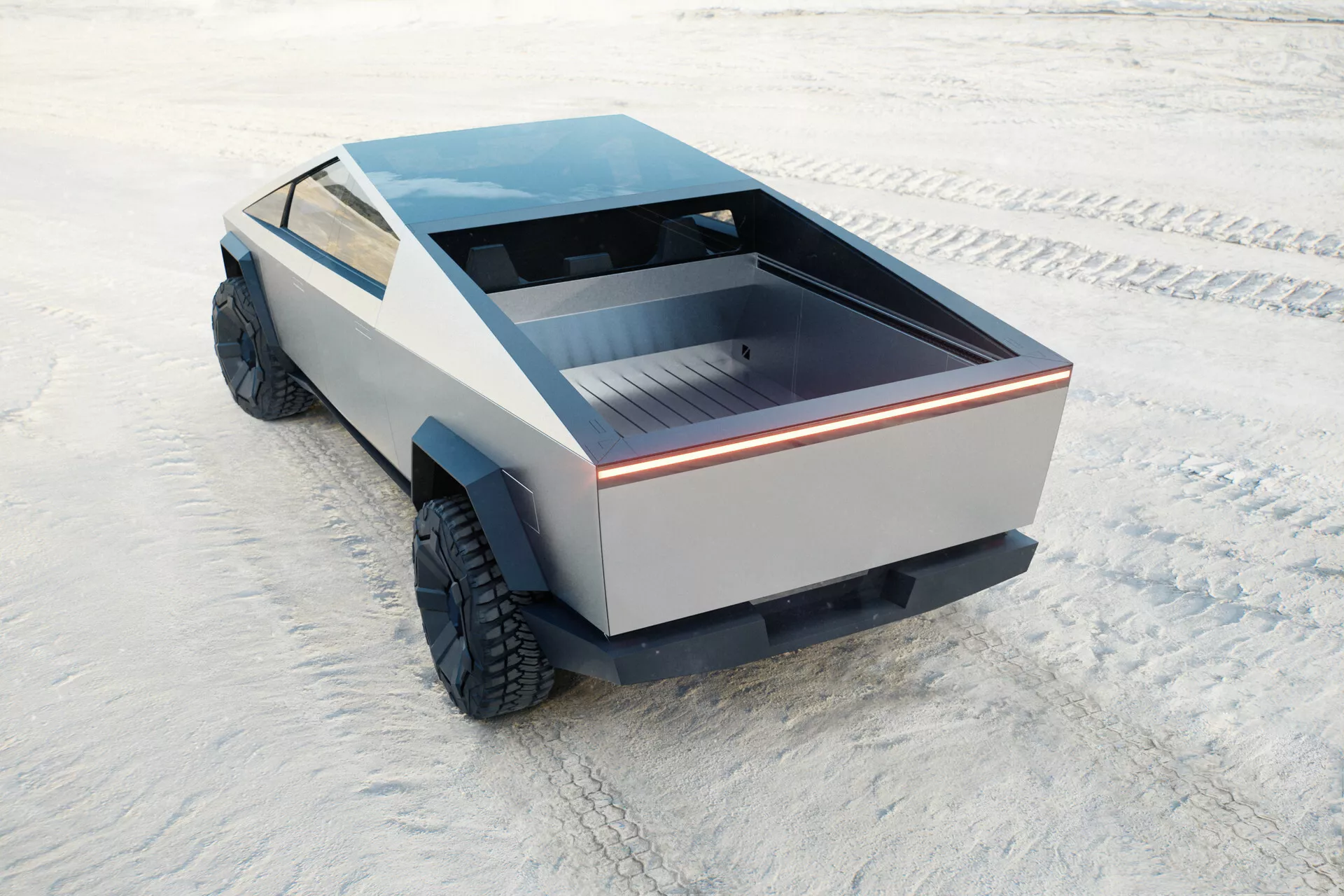 Futuristický a jedinečně vypadající Tesla Cybertruck 2021, první generace, zachycený z vysokého zadního čtvrtletního úhlu. Pohled zahrnuje zadní lože vozidla, část jeho bočního profilu a plochou střechu. Zadní lože je mělké s plochým povrchem, zvýrazněné nepřetržitým světelným proužkem, což podtrhuje moderní design. Boční panely postrádají konvenční styly a ukazují minimalistický přístup. Velké terénní pneumatiky naznačují schopnost pro jízdu v terénu. Nepřítomnost tradičních zrcadel a výfukových otvorů naznačuje možný elektrický pohon. Nákladní vůz je umístěn na plochém, texturovaném povrchu připomínajícím solné pláni.