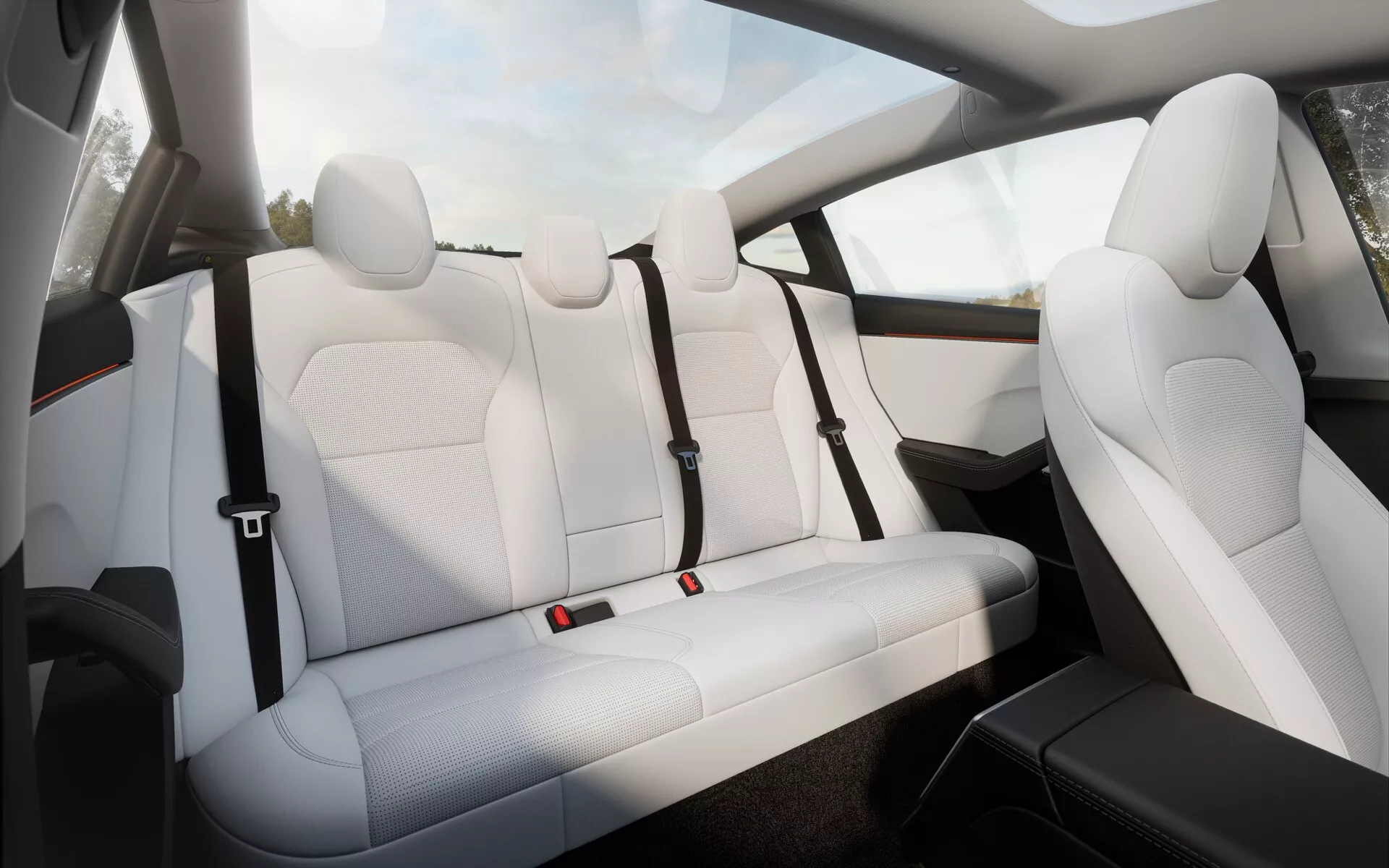 Interiér Tesla Model 3 (facelift první generace) pro rok 2023 se zaměřením na elegantně navržená zadní sedadla s prémiovým bílým prošitým koženým čalouněním, ergonomickou podporou a bezpečnostními pásy s červenými akcenty, spolu s náhledem na pokročilý audio systém ve dveřích.
