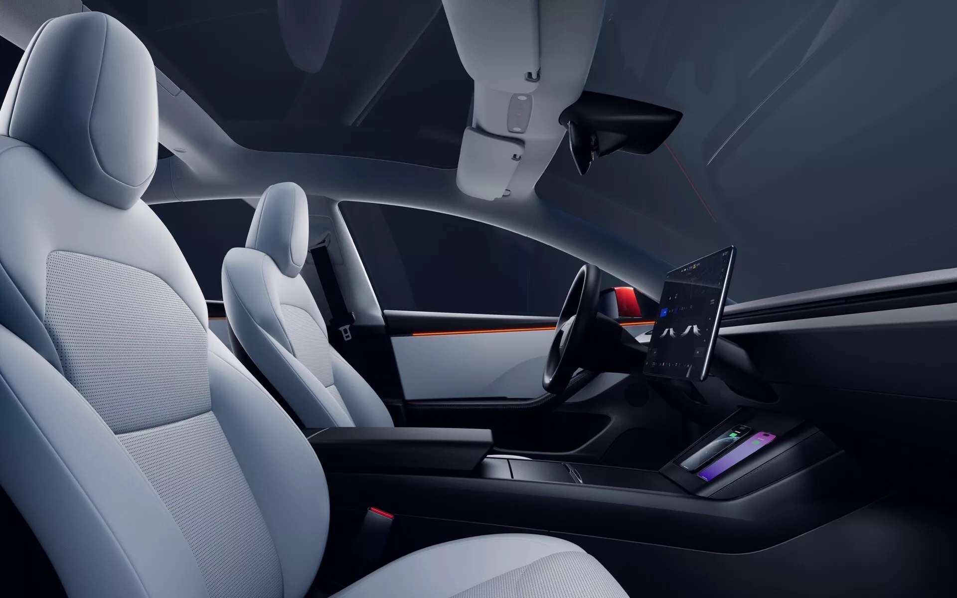 Interiér Tesly Model 3 (první generace facelift) z roku 2023 z pohledu spolujezdce, s moderním, minimalistickým předním interiérem, sedadly z kůže nebo koženky, širokou palubní deskou, minimalistickým dvouramenným volantem s integrovanými ovládacími prvky a elegantní středovou konzolí
