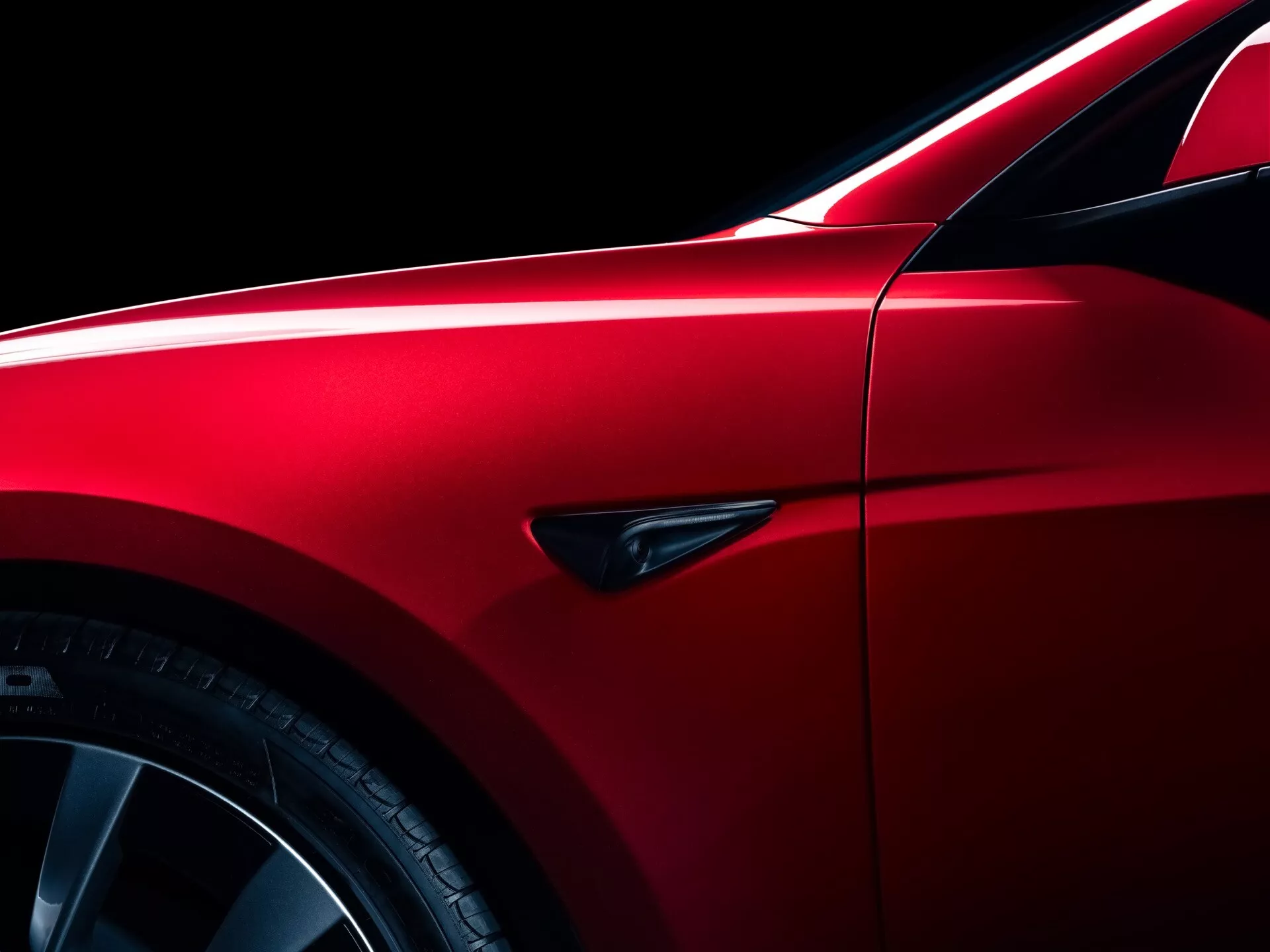 Facelift Tesla Model-3 2023 v metalické červené, předvádí elegantní aerodynamický design s důrazem na blatník, slitinová kola s více paprsky a sportovní pneumatiky s nízkým profilem, zvýrazněné přesnými mezerami panelů a charakteristickým bočním ukazatelem.