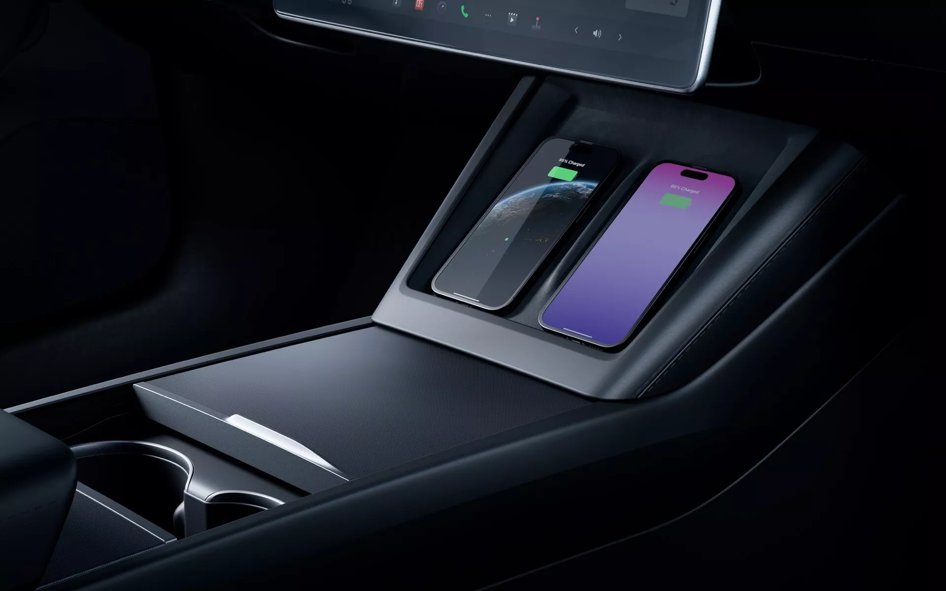 Detailní pohled na středovou konzolu faceliftu Tesla Model 3 2023 zahrnující bezdrátovou nabíjecí podložku, úložné prostory, držáky na nápoje, vysoce kvalitní materiály, ambientní osvětlení a digitální displej