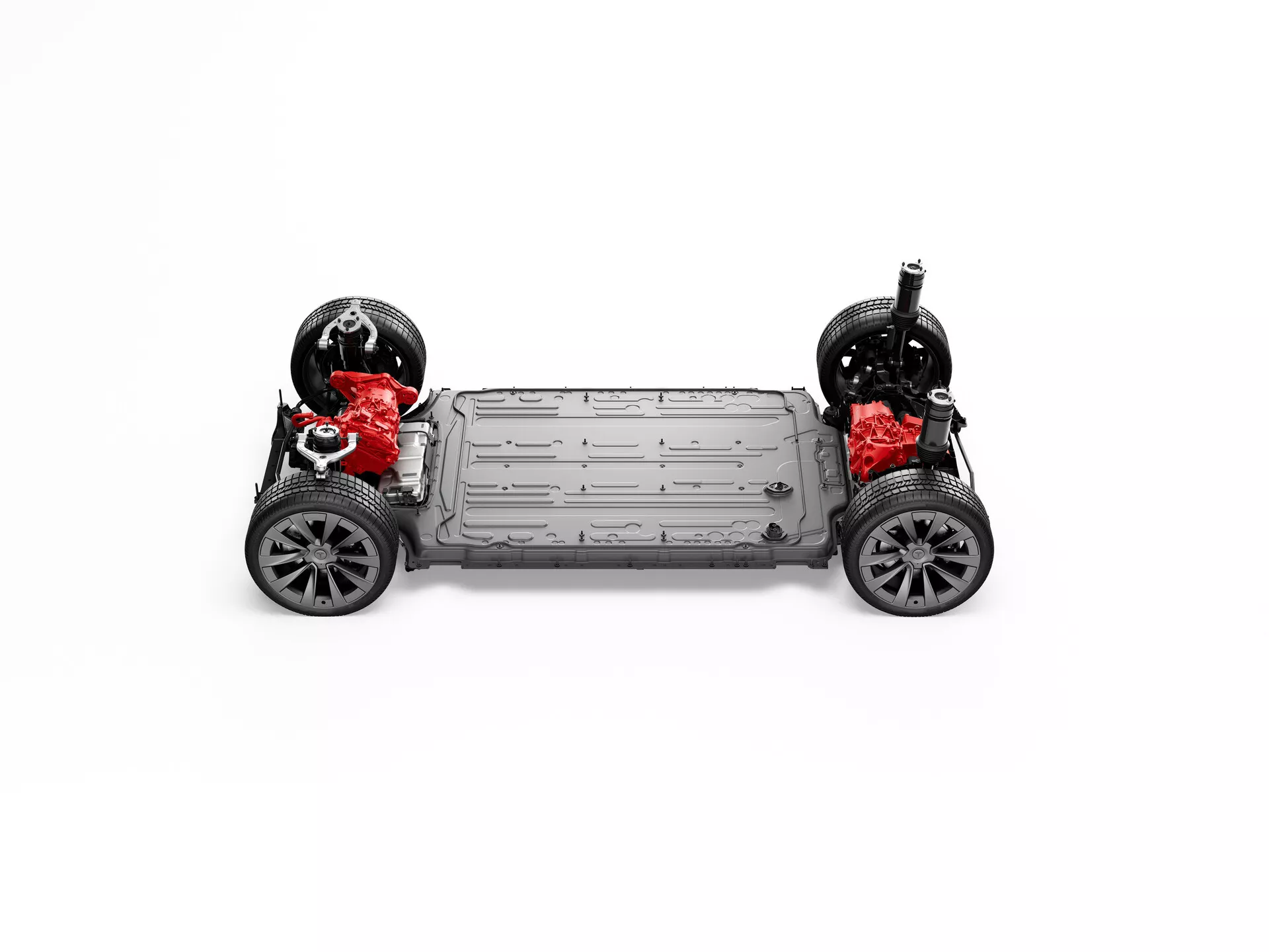 Pohled shora na podvozek vozu Tesla Model-X 2021 (1. generace facelift) bez karoserie, zobrazující kola s běhouny a velkými brzdovými kotouči, dvoumotorový pohon s červenými komponenty, centrálně umístěný bateriový paket, tuhý rám s bočními prahy, ploché spodní tělo a nezávislé zavěšení s červenými tlumiči; umístěný na bílém pozadí.