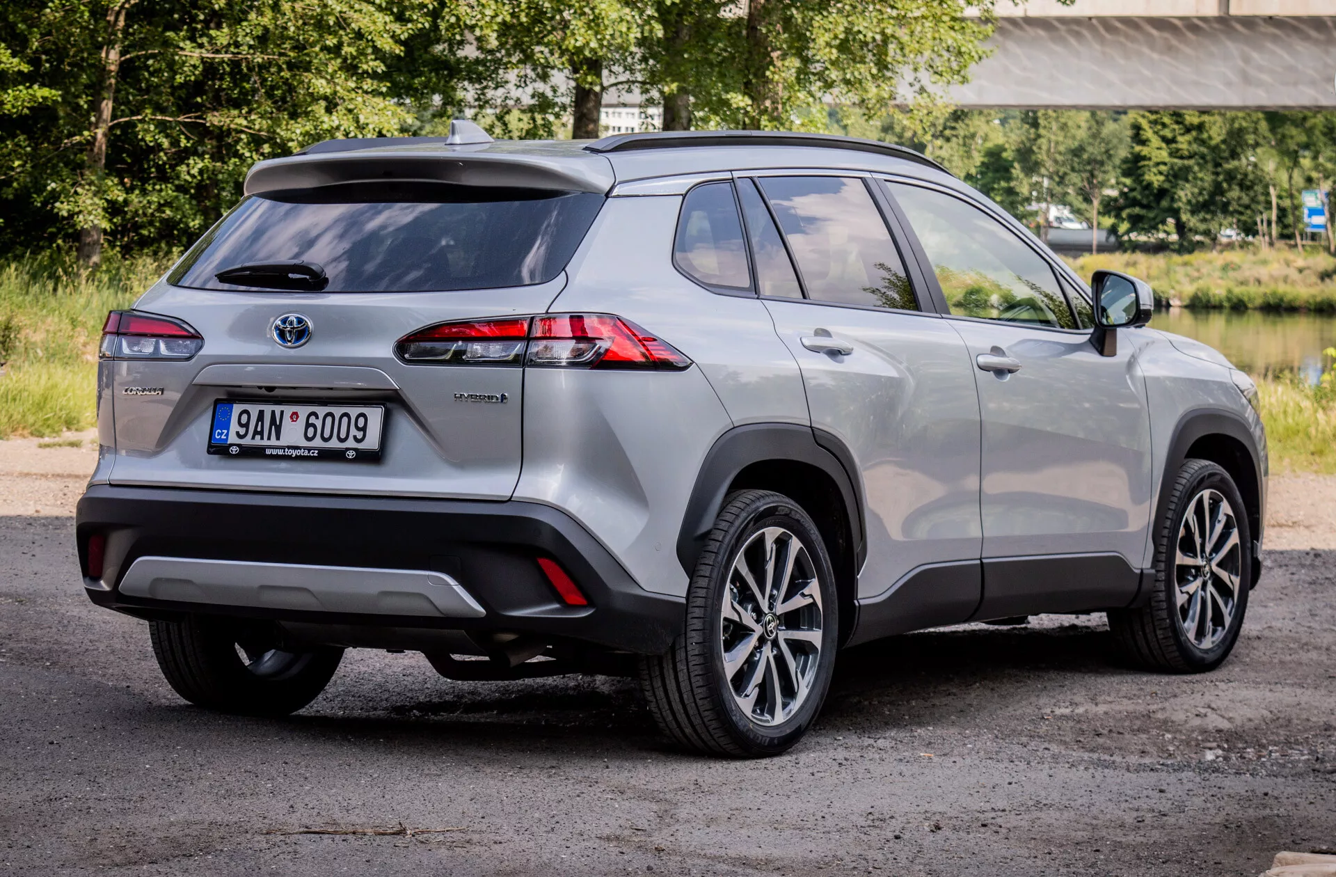 Hybridní kompaktní SUV Toyota Corolla Cross 2022 ukazující pokročilá LED zadní světla, slitinová kola a bezpečnostní prvky z pohledu ze zadního tříčtvrtečního úhlu.