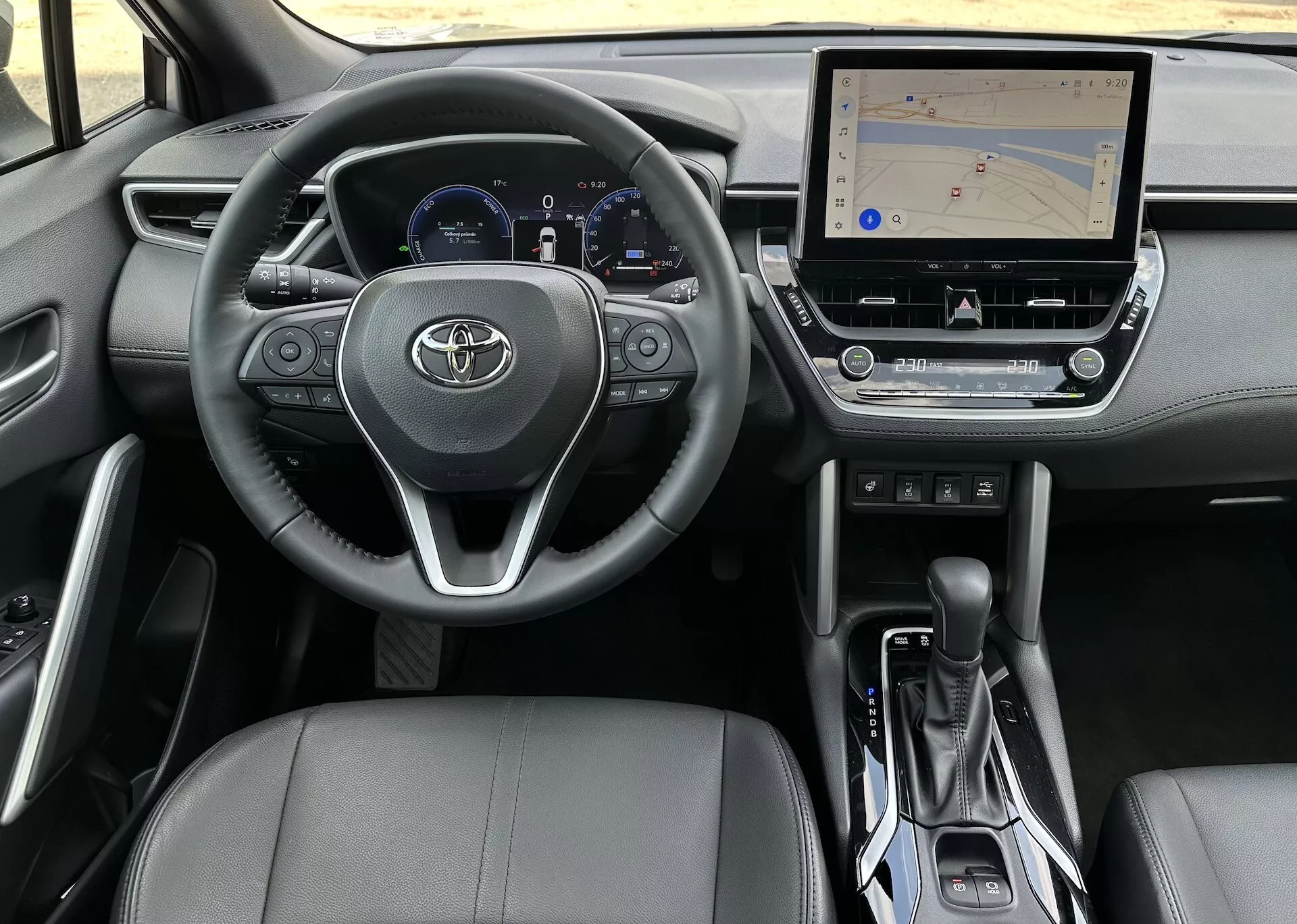Interiér Toyota Corolla Cross 2022 z pohledu řidiče s volantem, přístrojovým panelem, středovou konzolou a sedadlem spolujezdce