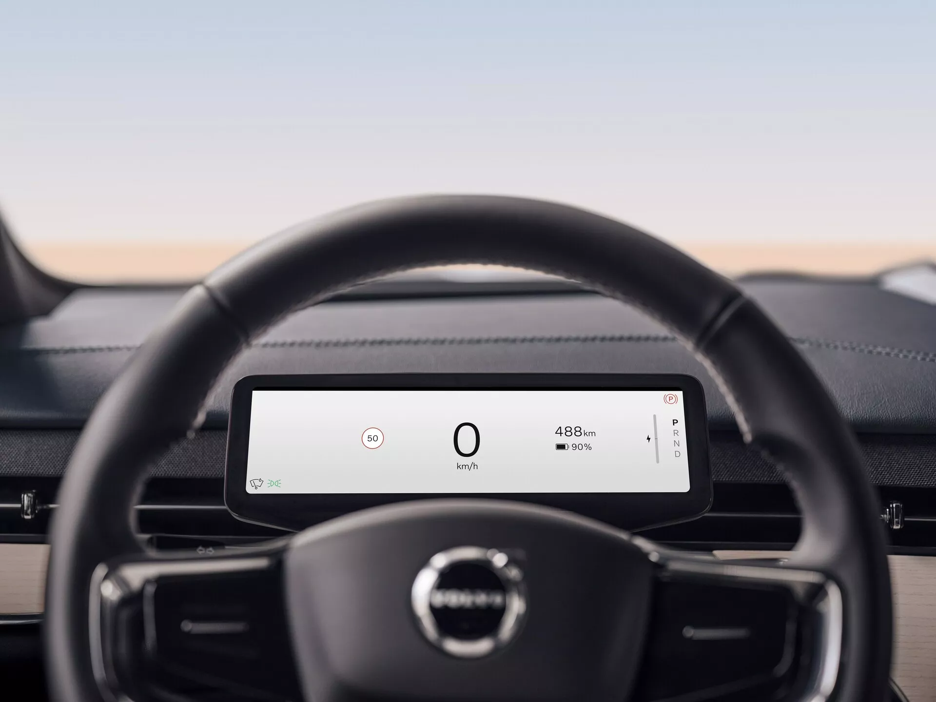 Interiér Volvo EX90 2023 s důrazem na kožený volant a digitální palubní desku zobrazující rychlost a dojezd baterie