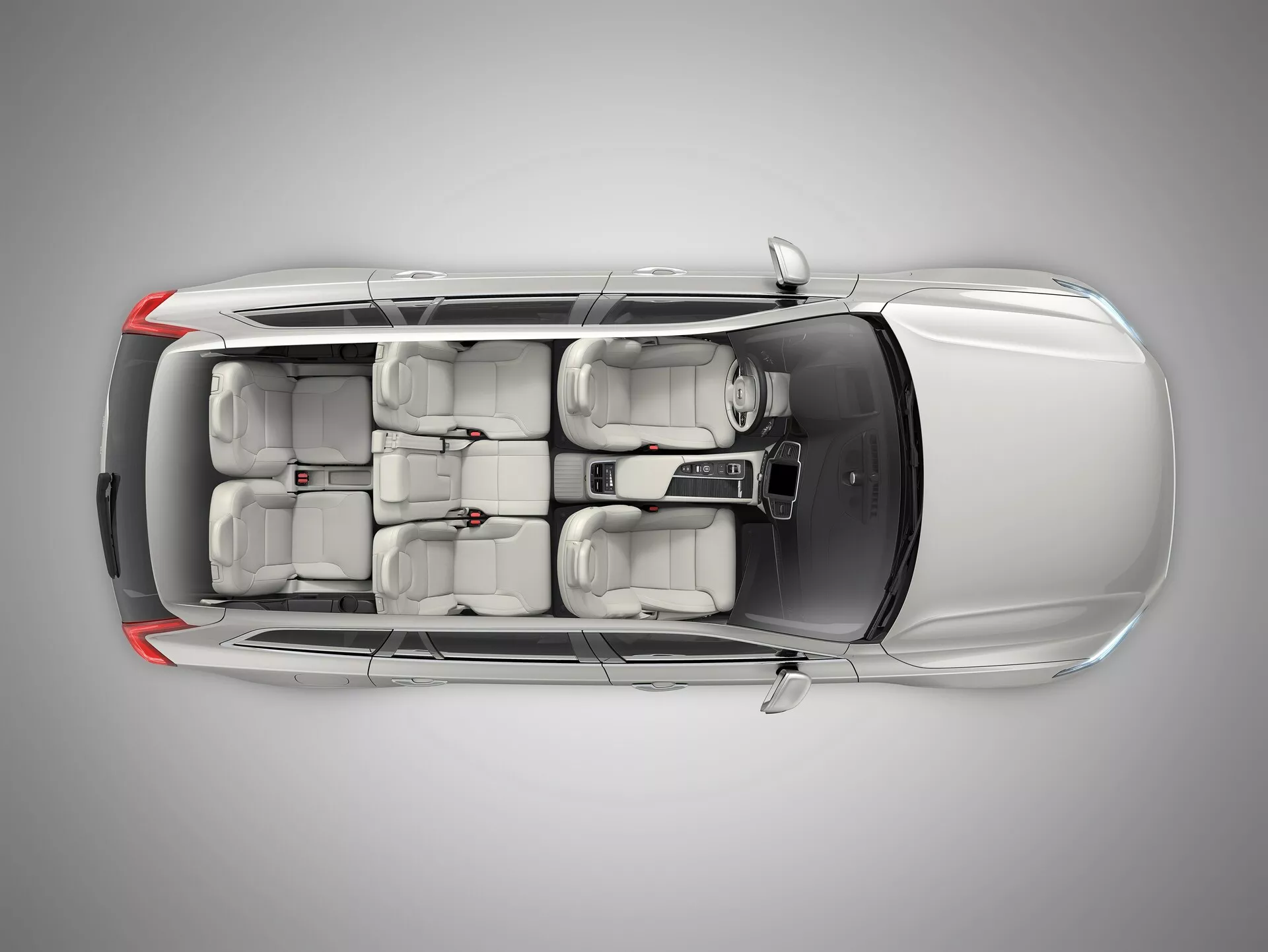 Pohled shora na Volvo XC90 2015 (2. generace), zobrazující střechu se střešním oknem nebo moonroof panelem, čtyři dveře se zapuštěnými madly a třířadé sedadla pro sedm cestujících, což naznačuje moderní design a uspořádání s volantem vlevo.