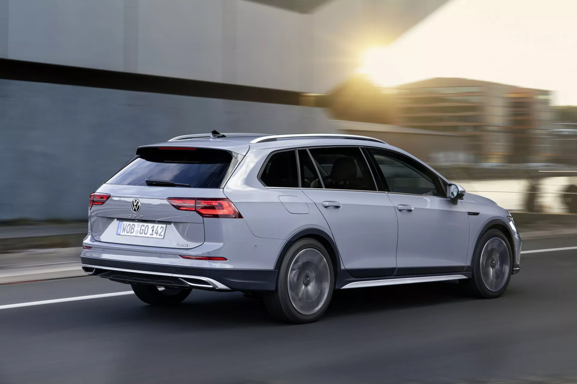 Volkswagen Golf Alltrack kombi 2017 v pohybu, zachycený v dynamickém pohledu ze zadního tříčtvrtečního úhlu předvádějící stříbrnou karoserii, LED zadní světla, slitinová kola a aerodynamický design na rozostřeném pozadí silnice.