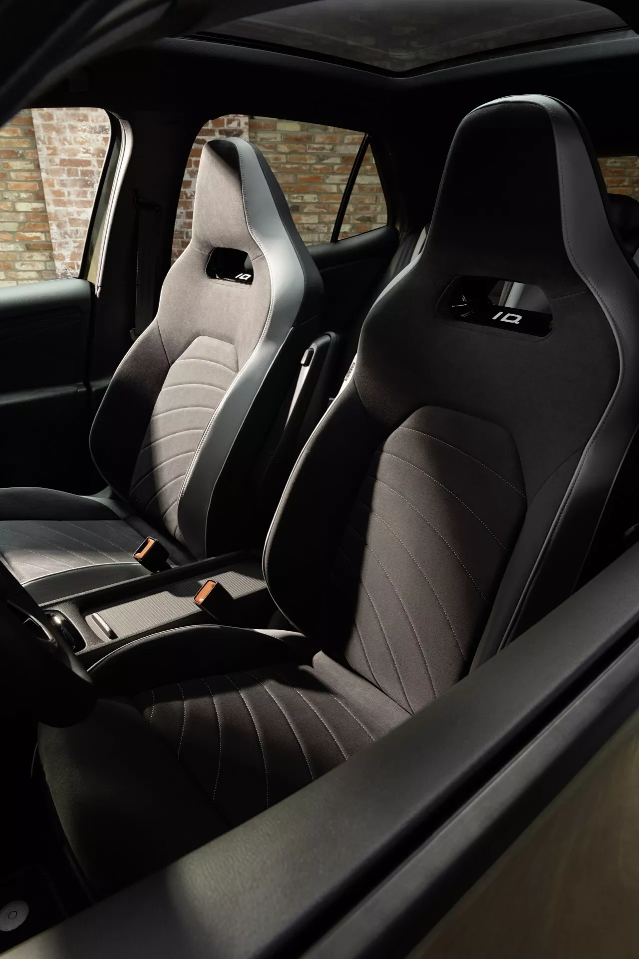 Interiér VW ID.3 facelift 2023 se zaměřením na sportovní přední sedačky typu bucket z prošívaného prémiového materiálu s elegantní černou barevnou schémou, zdůrazňující ergonomický design a luxus.