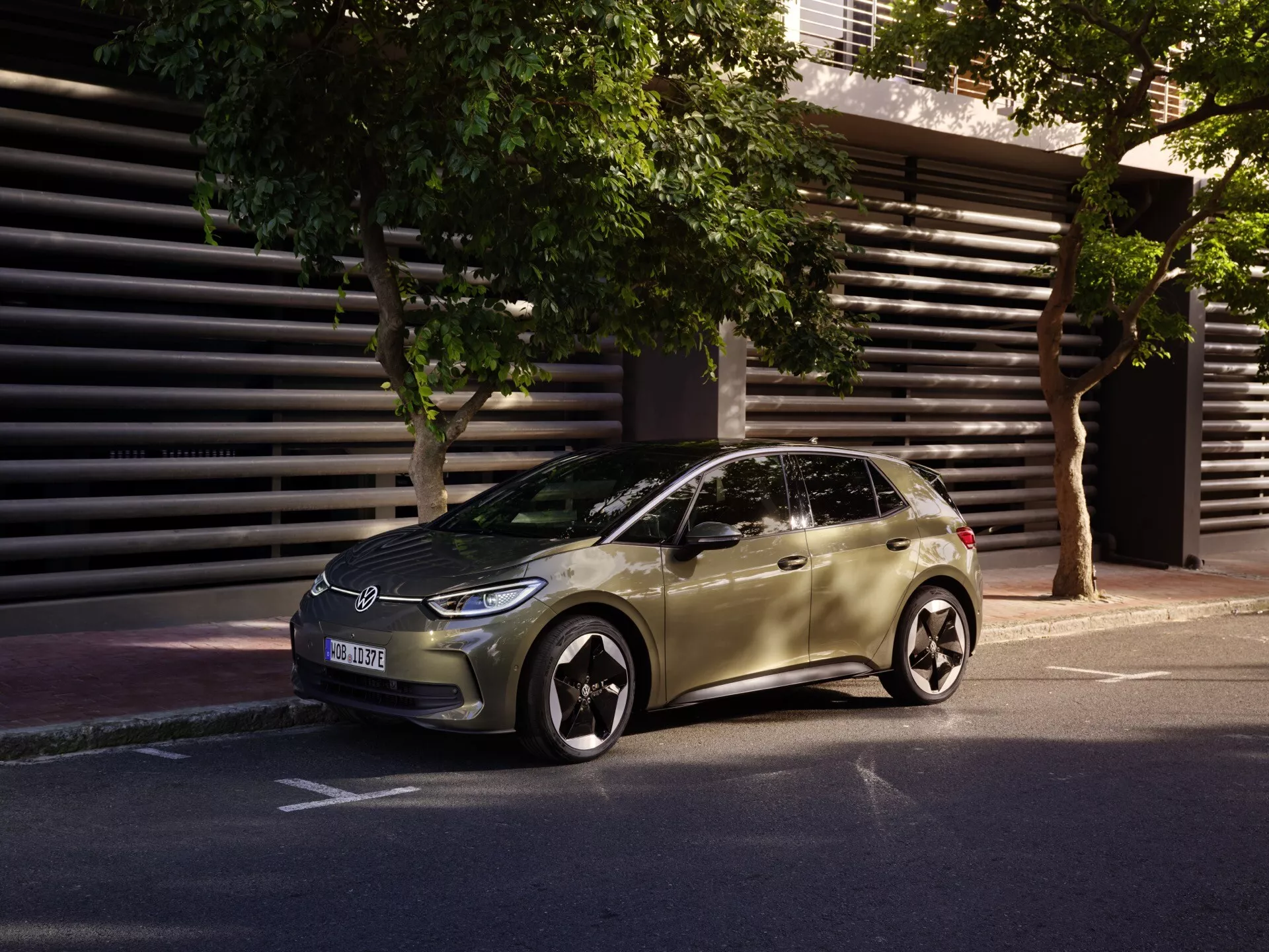 VW ID.3 1. generace facelift model 2023 – Štíhlý hatchback parkovaný na městské ulici ve tříčtvrtečním předním pohledu zdůrazňující LED světlomety, slitinová kola a aerodynamický design v ranním nebo odpoledním světle