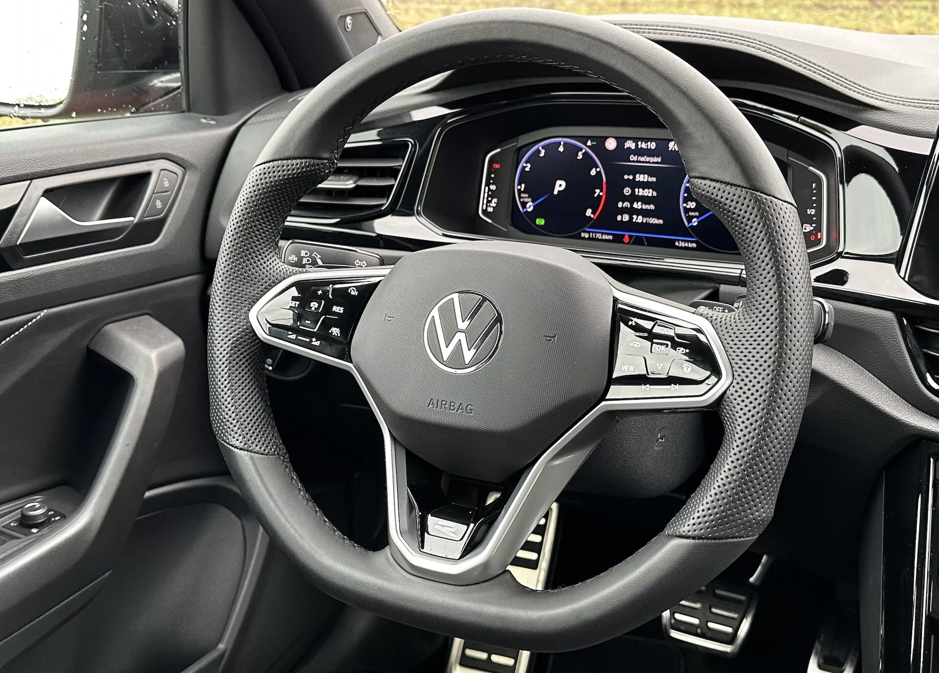 Detailní pohled z perspektivy řidiče na volant a digitální přístrojovou desku kabrioletu Volkswagen T-Roc 2022, předvádějící moderní design a technologické funkce