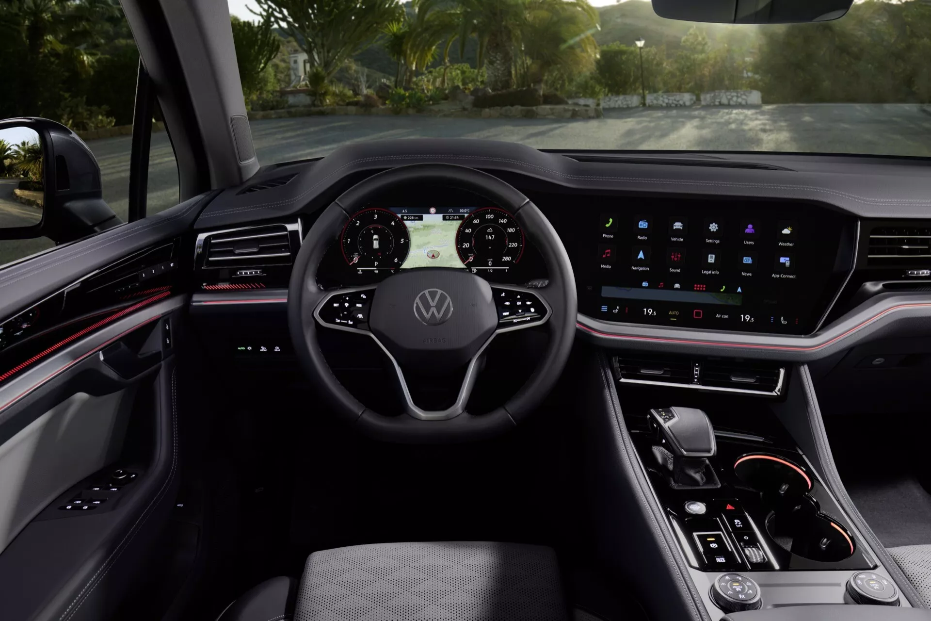 Interiér Volkswagen Touareg (III-Facelift) 2023 s digitálním palubním přístrojem, multifunkčním volantem se znakem Volkswagen, integrovaným dotykovým displejem infotainmentu, minimalistickými ovladači na středové konzoli a sofistikovaným tmavým barevným schématem s ambientním osvětlením