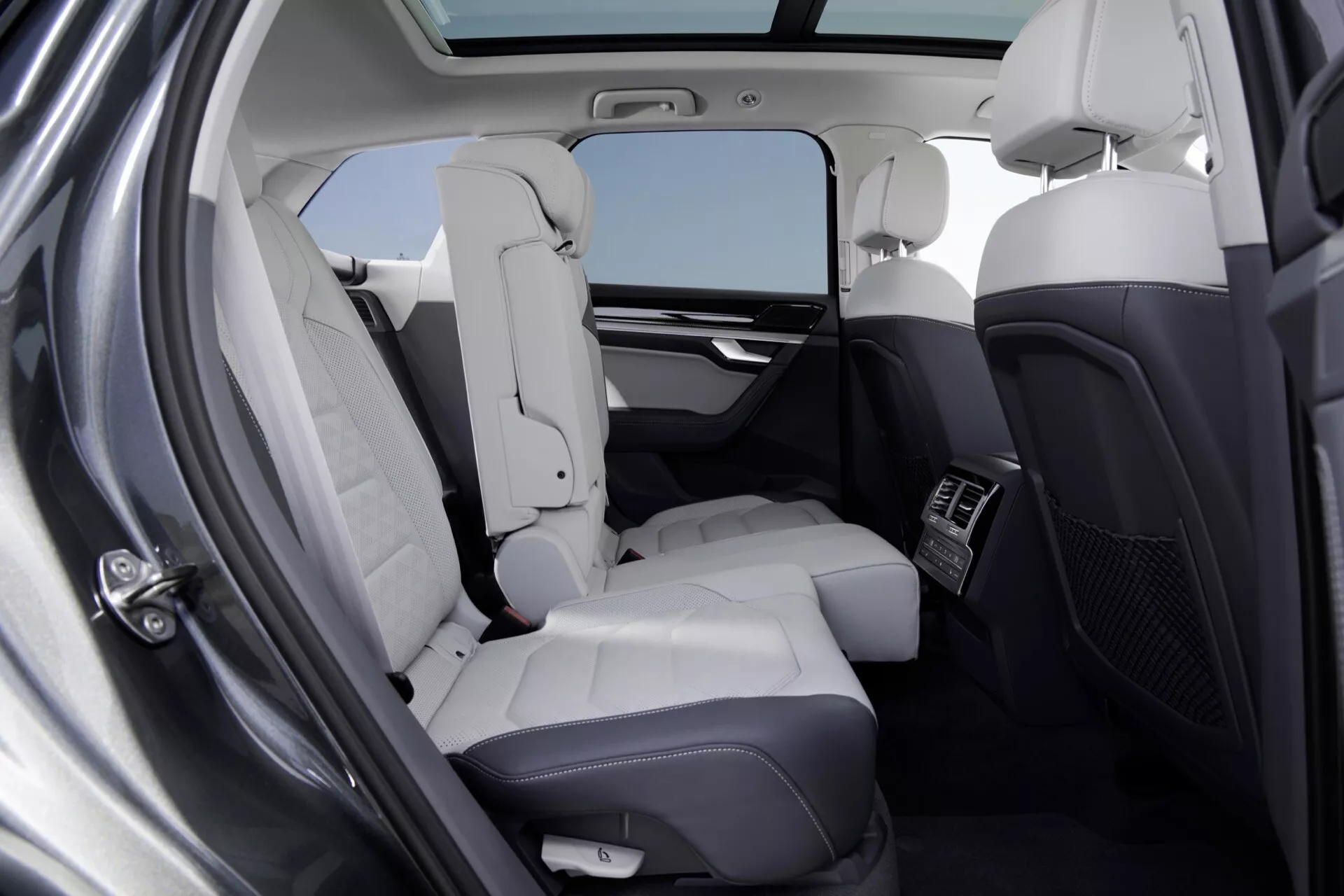 Interiér Volkswagen Touareg 2023 (III-Facelift) ukazující luxusní zadní oddíl pro cestující s koženými sedadly, panoramatickým střešním oknem a prostornou nožní částí