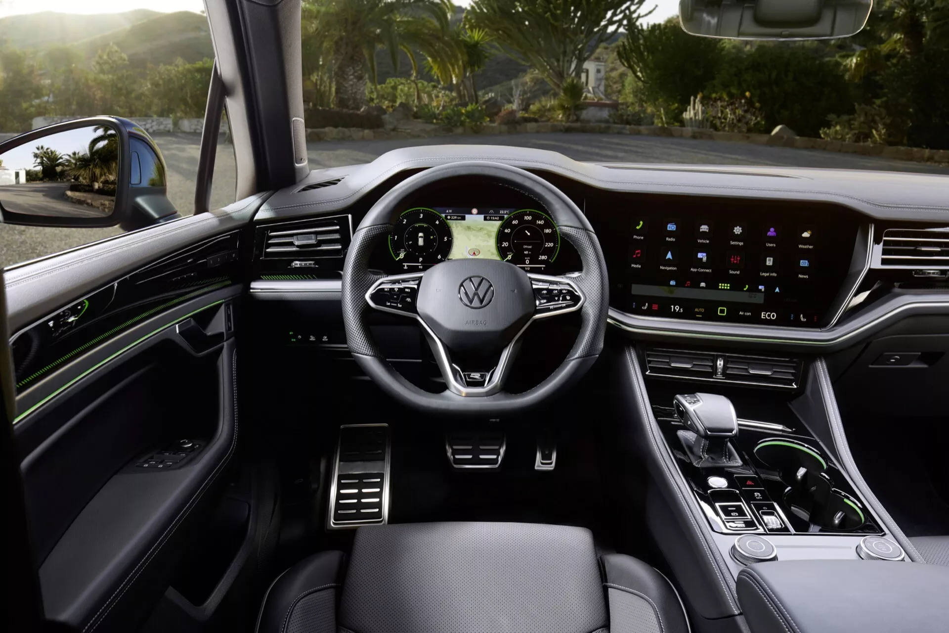 Interiér Volkswagen Touareg 2023 z pohledu řidičova sedadla s volantem s integrovanými ovladači, digitálním přístrojovým panelem, dotykovým infotainment systémem, elegantní řadicí pákou a prémiovým čalouněním s ambientním osvětlením