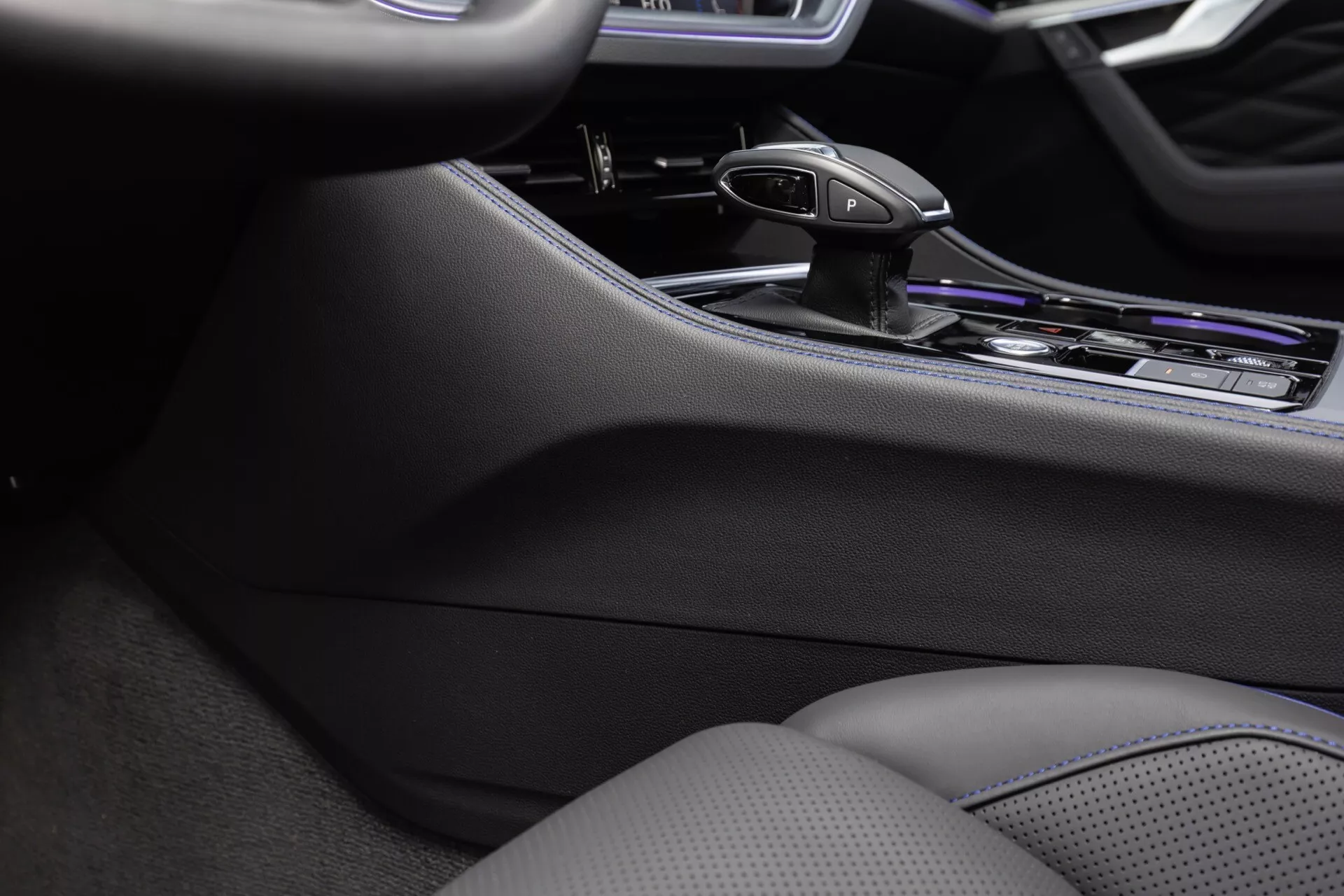Detail interiéru Volkswagen Touareg 2023 s důrazem na středovou konzolu, ergonomickou páku automatické převodovky a prémiové chromované povrchy, zdůrazňující pokročilé ovládání infotainmentu a klimatizovaná sedadla