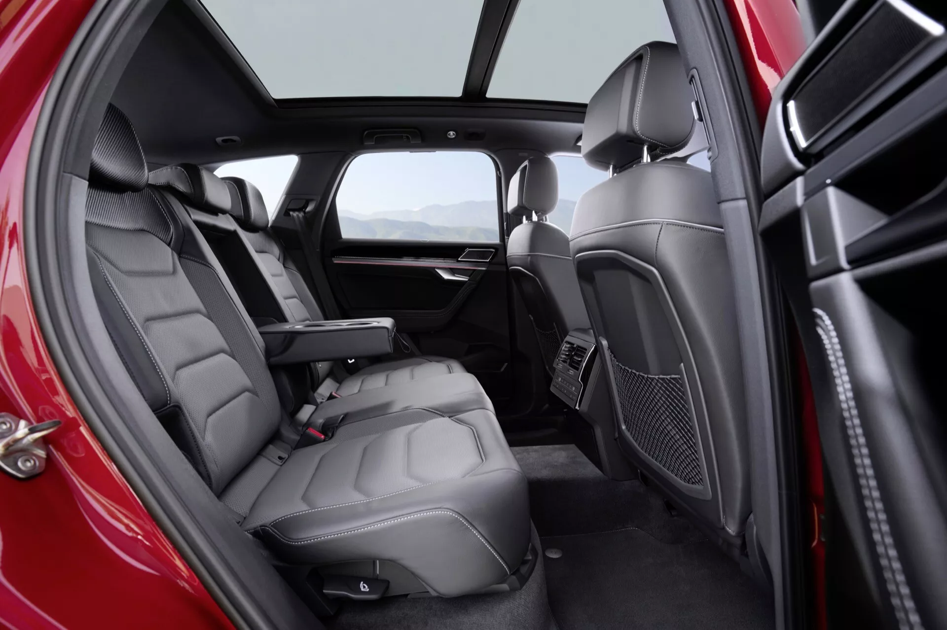Interiér VW Touareg III po modernizaci v roce 2023, který zdůrazňuje luxusní zadní sedadla z kůže a pokročilé prvky pohodlí pro cestující, s přirozeným osvětlením a dvoubarevným barevným schématem
