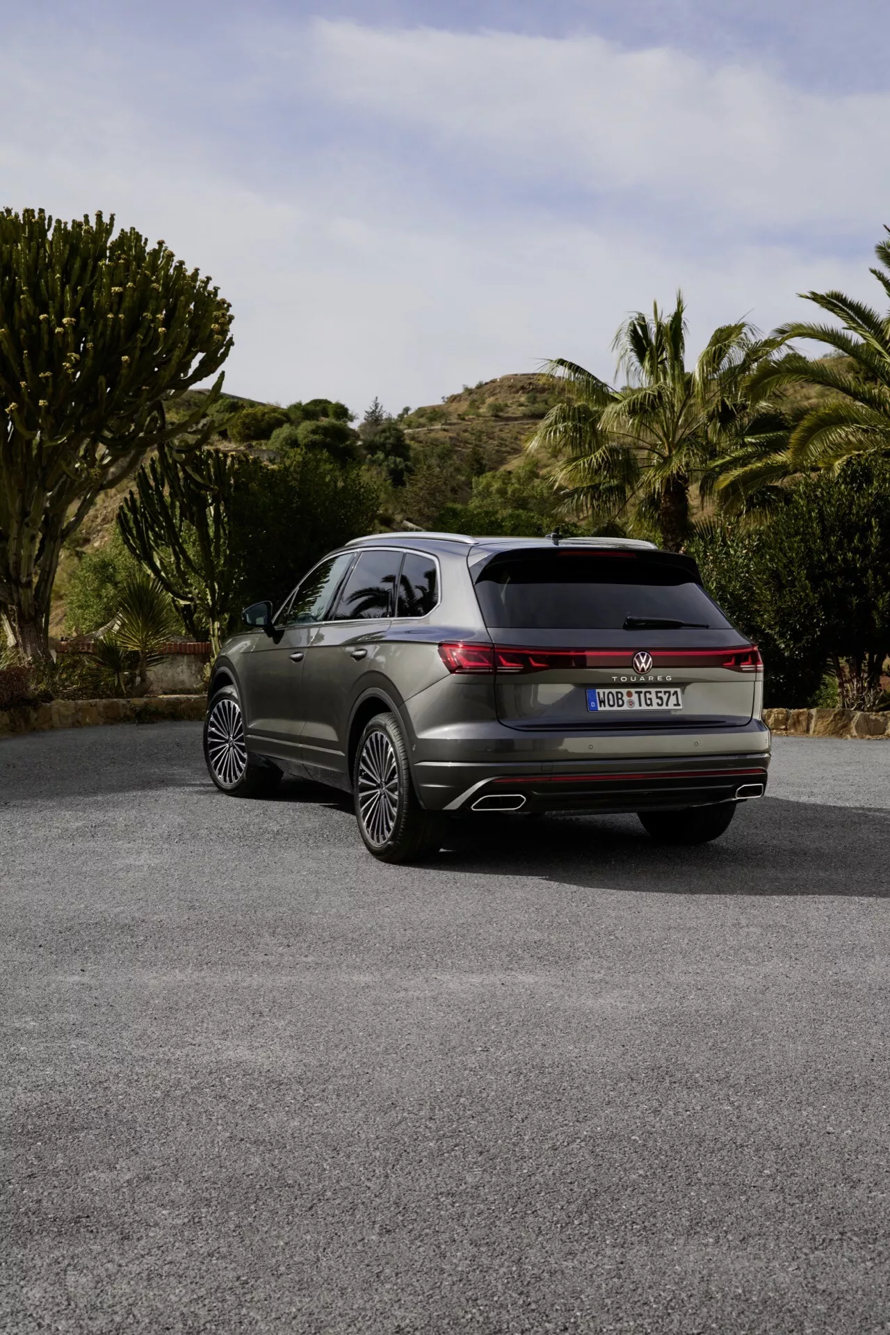 VW Touareg 2023 (III-facelift) zobrazený z úhlu tři čtvrtě zezadu s LED zadními světly, dvojitými výfuky a prémiovými slitinovými koly na poloselské cestě