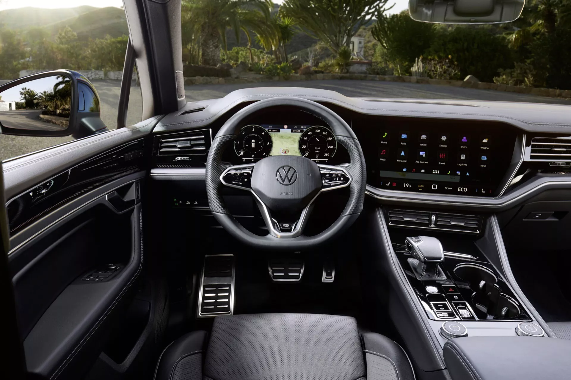 Interiér VW Touareg 2023 se zaměřením na perspektivu řidiče včetně multifunkčního volantu, širokého dotykového displeje na palubní desce a povrchů z vysoce kvalitních materiálů