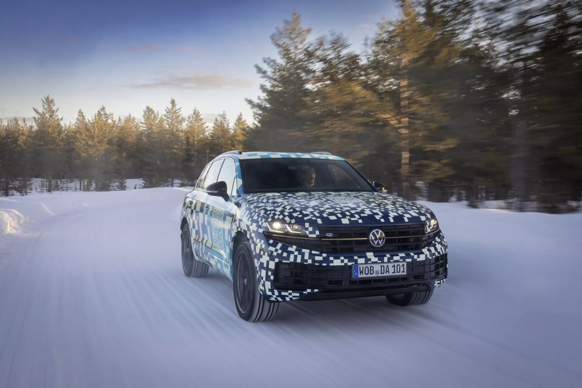 Model VW Touareg III Facelift 2023 zachycený v pohybu na zasněžené krajině, který předvádí dynamické schopnosti a pokročilé technologické funkce z perspektivy tří čtvrtin zepředu